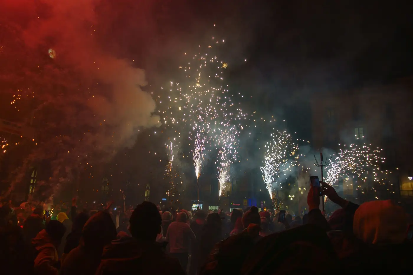 Vuurwerk boven een verlicht plein in het donker
