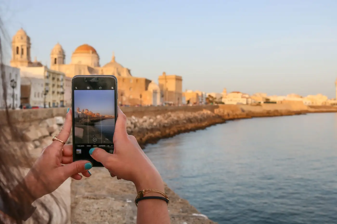 Toeriste maakt een foto van de kust met haar smartphone