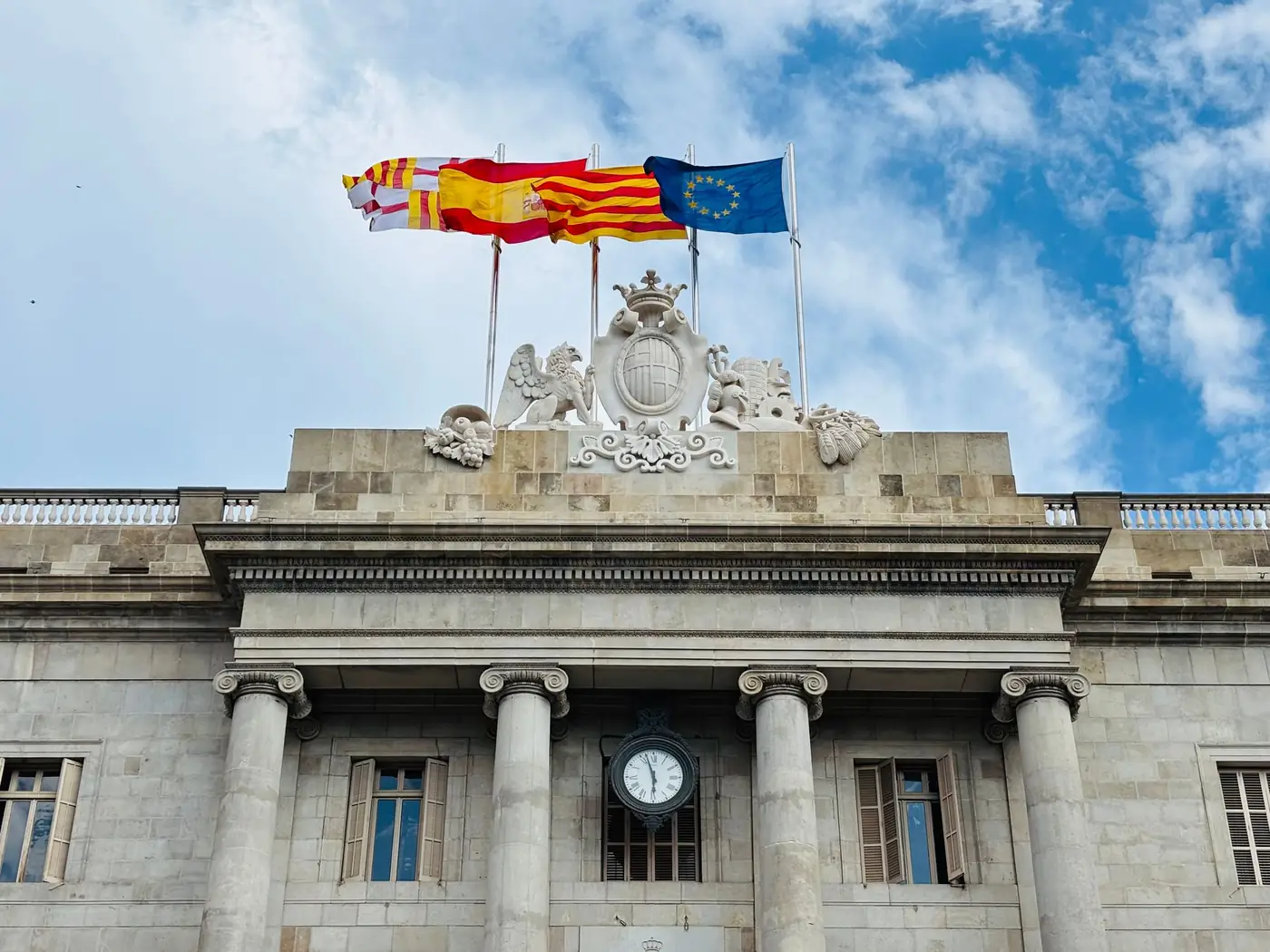 Gevel van een historisch gebouw met de Spaanse, Europese en regionale vlag