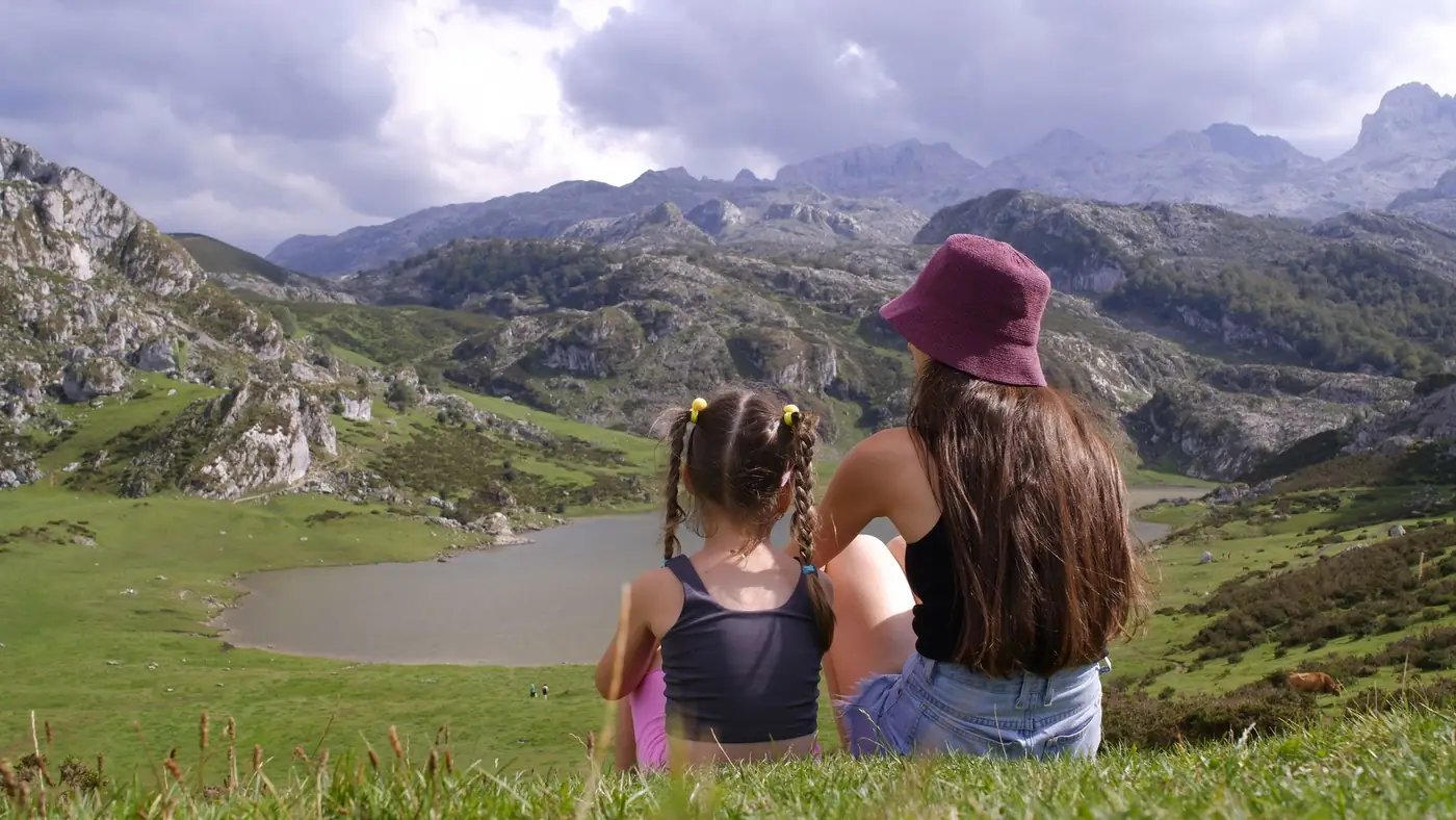 Bezoekers kijken uit over de Lagos de Covadonga met bergen op de achtergrond