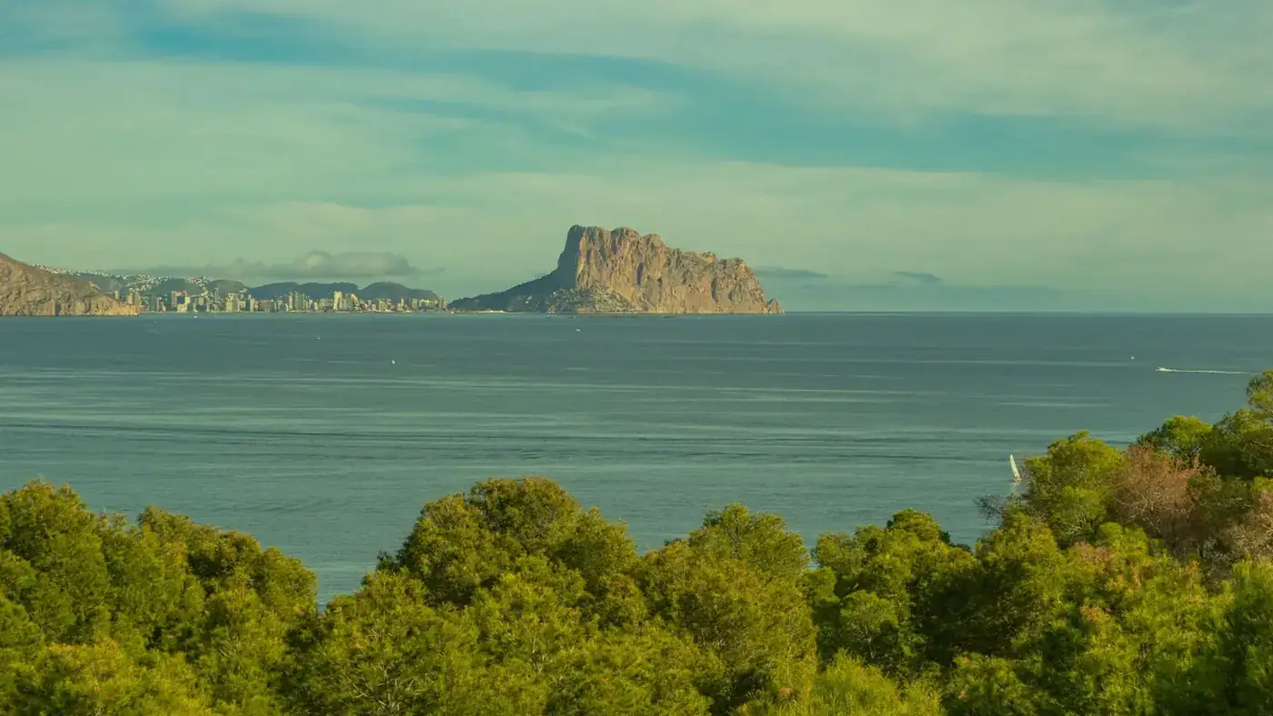 Stunning view of Peñón de Ifach and Calpe coastline under a clear, bright sky.