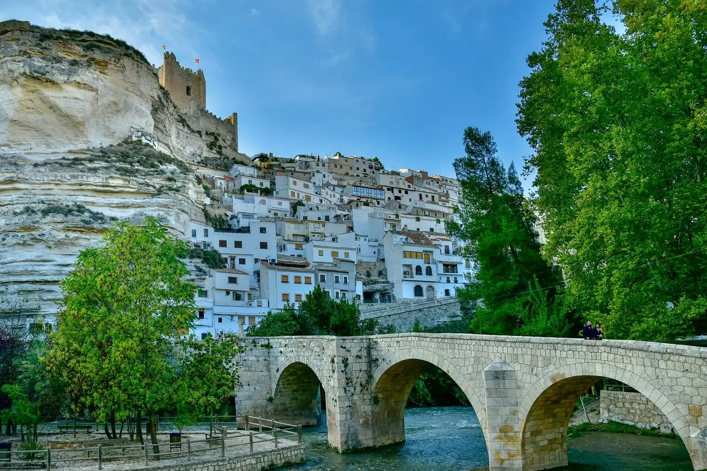 Picturesque Alcalá del Júcar with its distinctive cliffside houses and historic bridge in Spain.