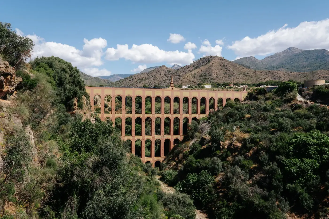 A stunning view of the Eagle Aqueduct set against the mountainous landscape of Nerja, Spain.
