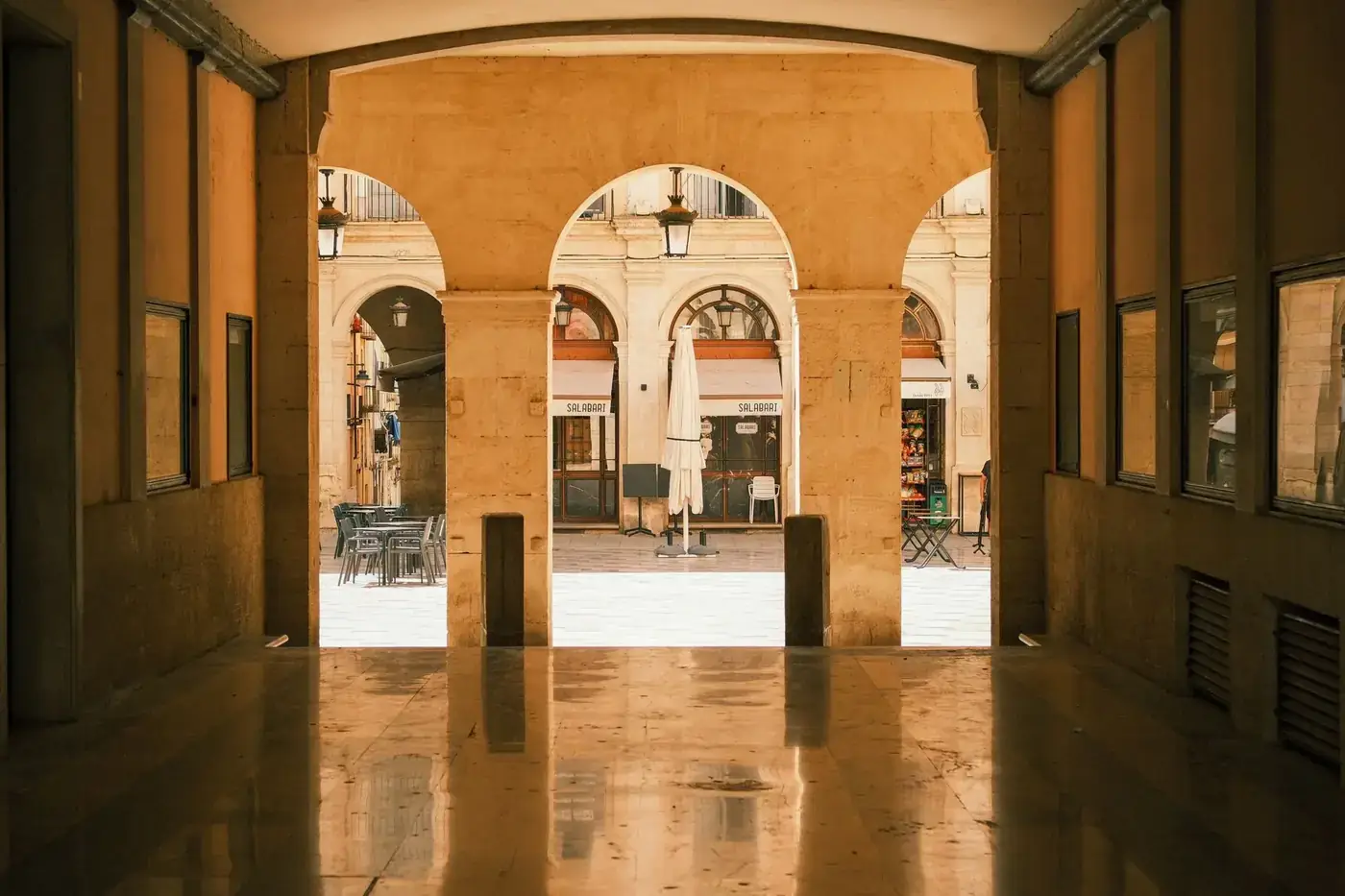 View through archway showcasing Alcoi's historic architecture with outdoor seating.