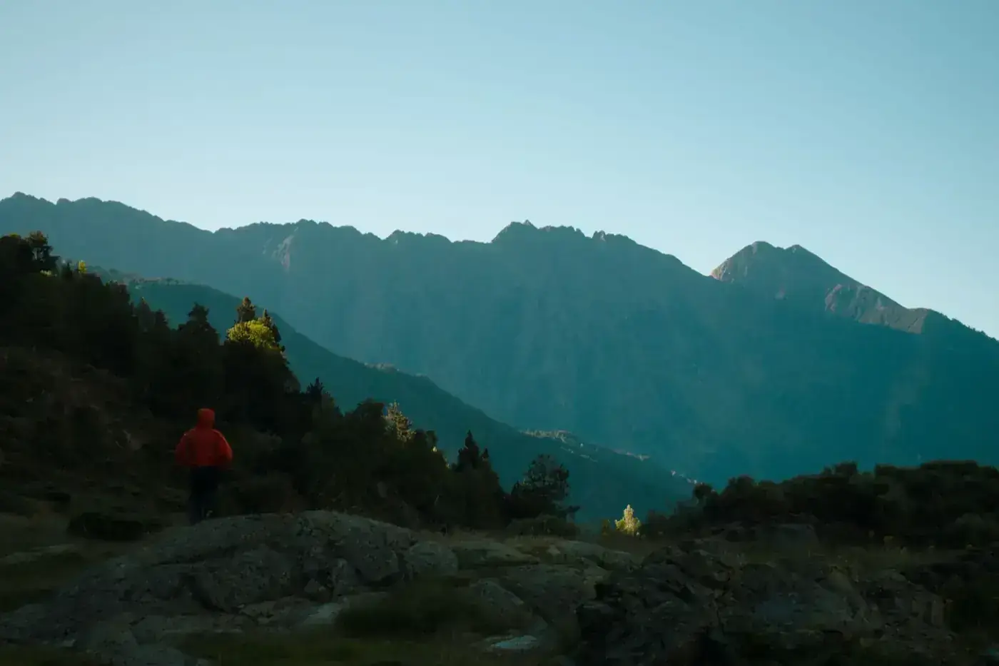 A lone hiker explores the serene landscapes of Llavorsí, Spain, surrounded by rugged mountain beauty.