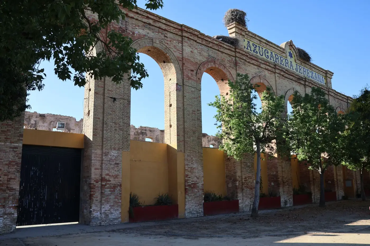 Explore the rustic charm of Azucarera Jerezana's brick arches in sunny El Portal, Andalucía.