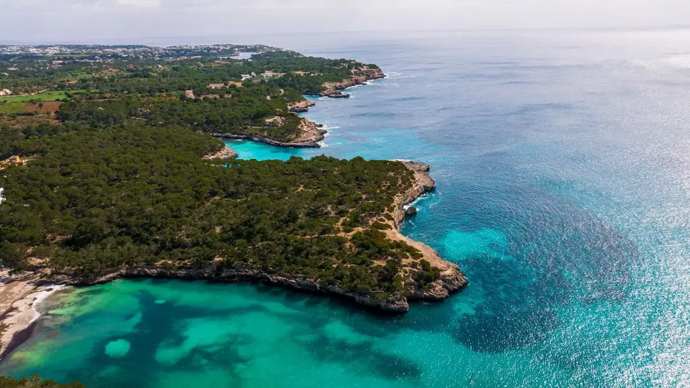 Breathtaking aerial shot of Mallorca's turquoise waters and rugged coastline in Islas Baleares, Spain.
