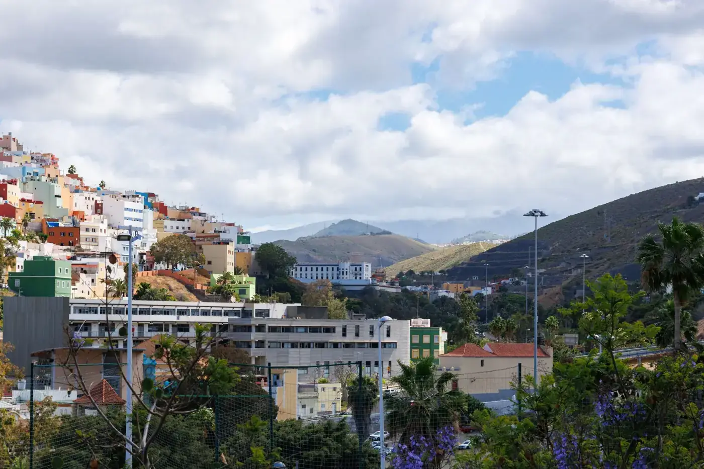 Vibrant cityscape of Las Palmas with colorful buildings and rolling hills.