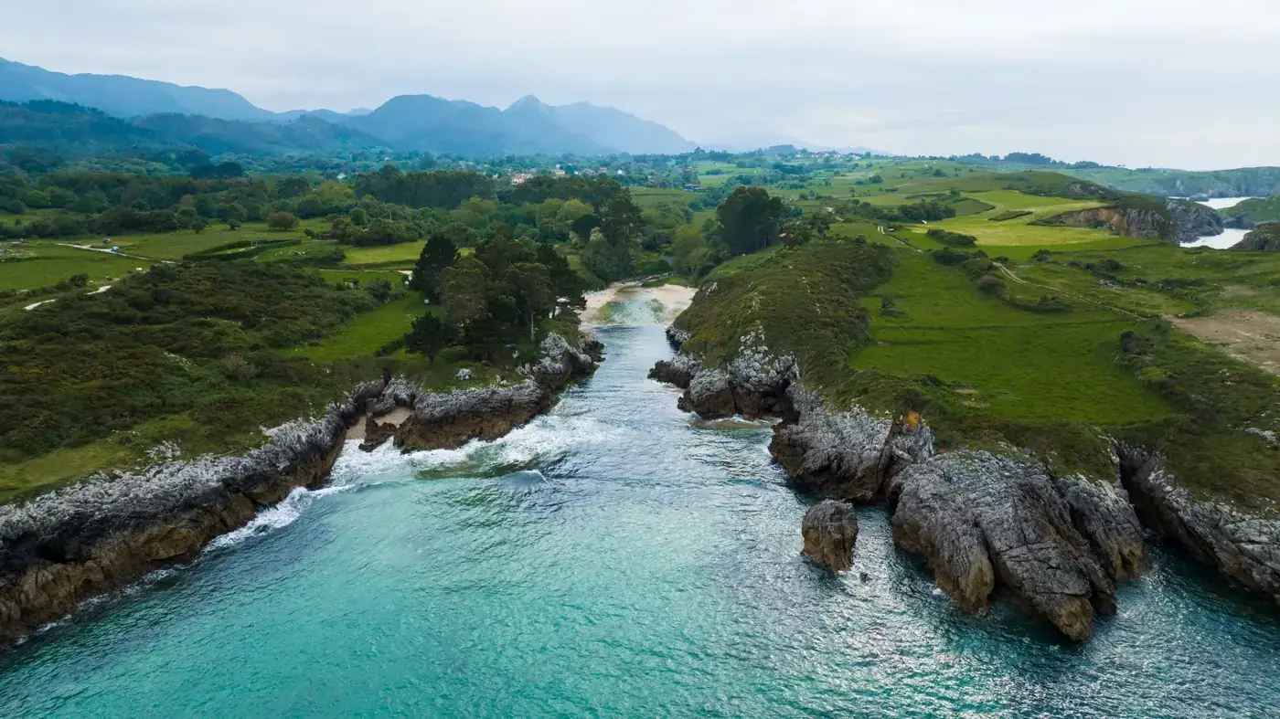 A breathtaking aerial view of the picturesque Spanish coastline with lush greenery and turquoise waters.