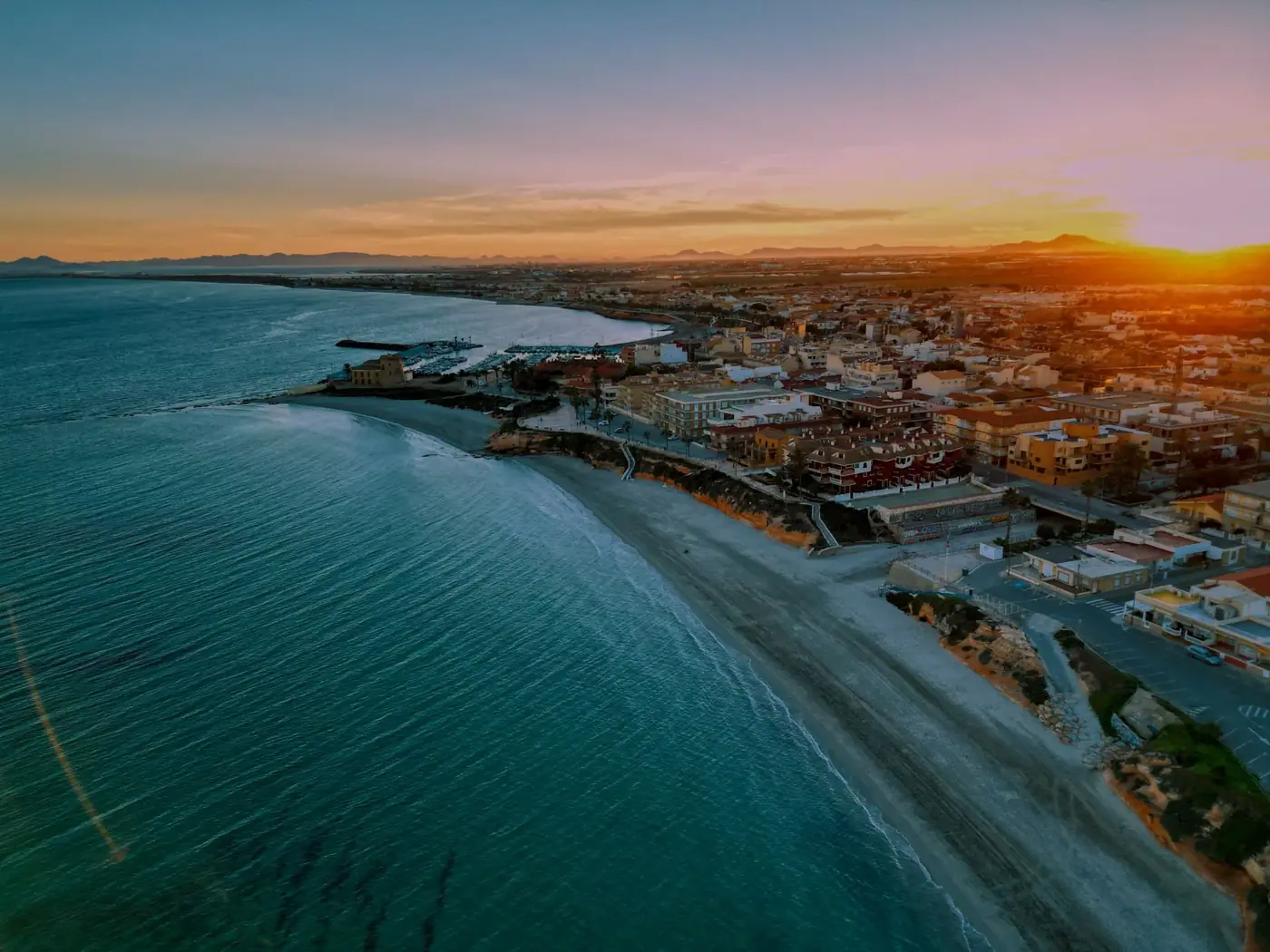 Stunning aerial view of Torre de la Horadada's coastline during a vibrant sunset, showcasing the city's charm.