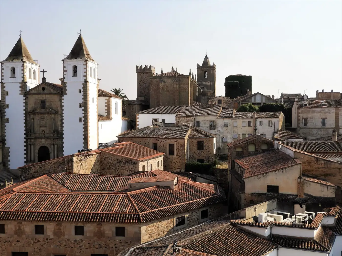 Aerial view of the historic architecture of Cáceres, Spain showcasing old stone buildings and churches.