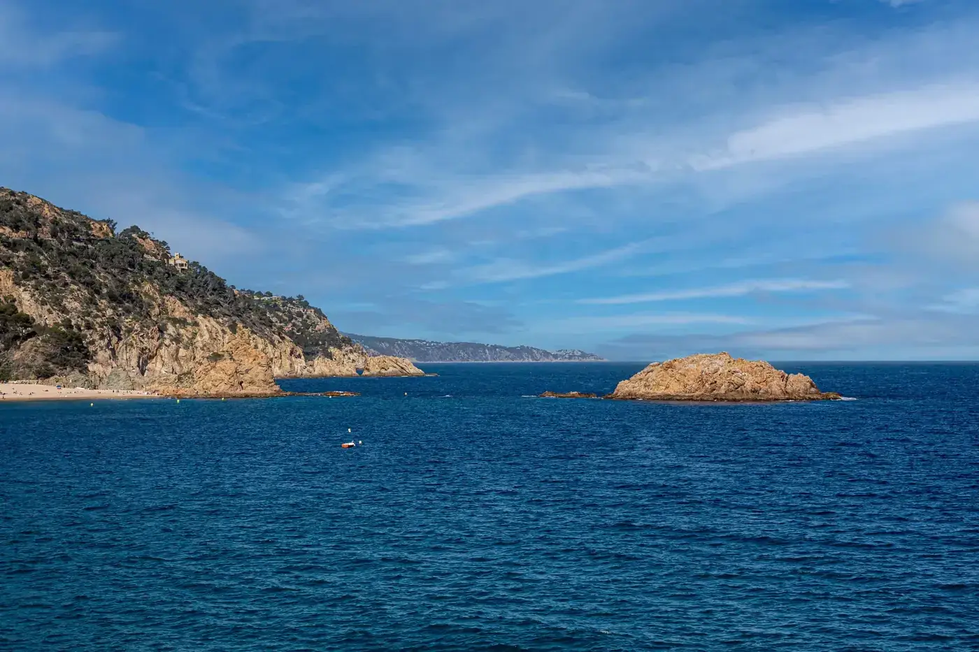 A breathtaking view of the rocky coastline and clear blue waters of Tossa de Mar, Spain.