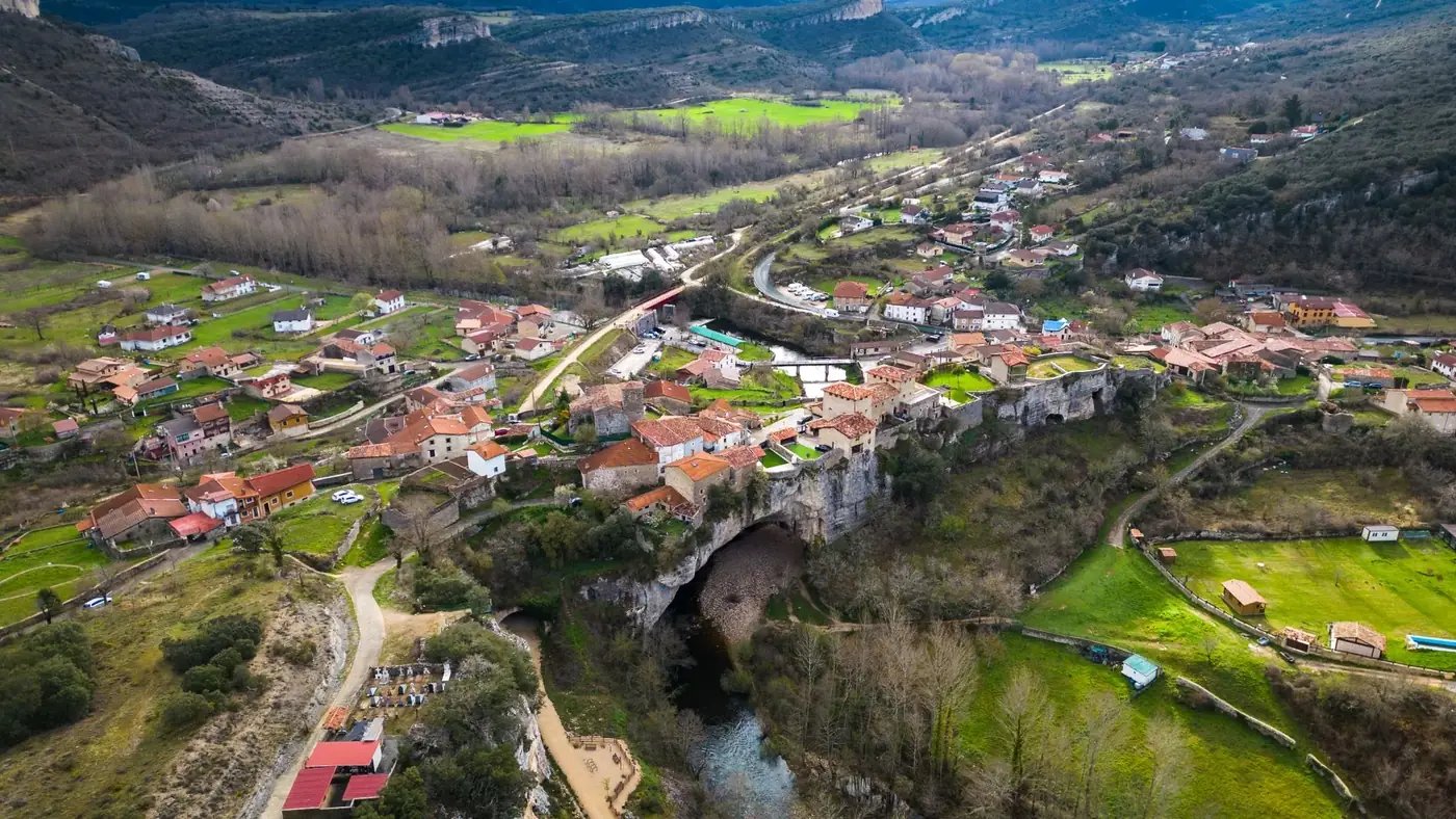 Stunning aerial photograph of Puentedey village in Castilla y León, Spain, showcasing unique natural bridge formation.