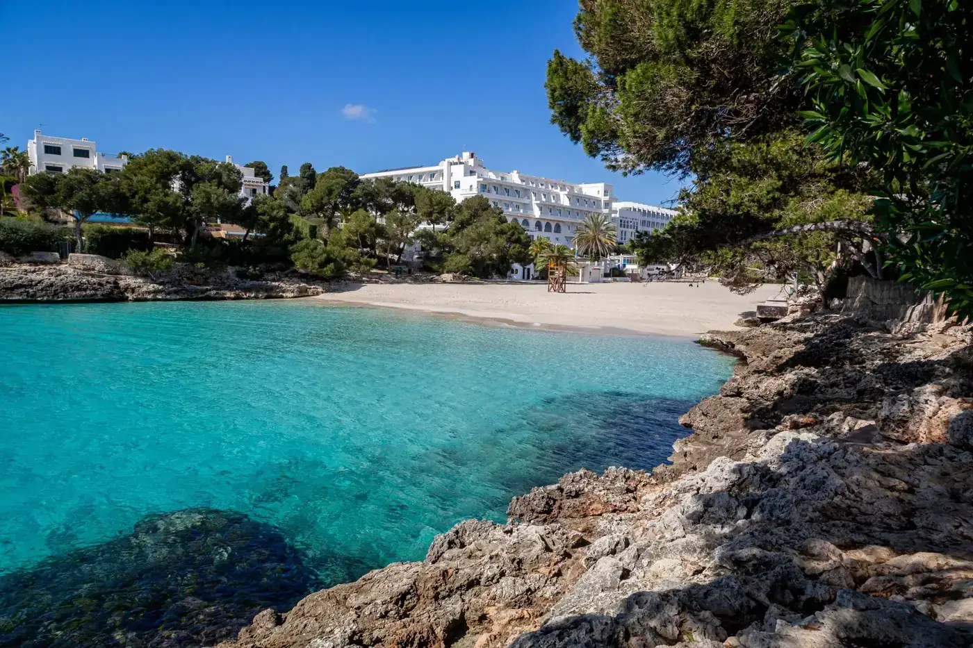 Picturesque beachfront resort with turquoise waters and sandy shores.
