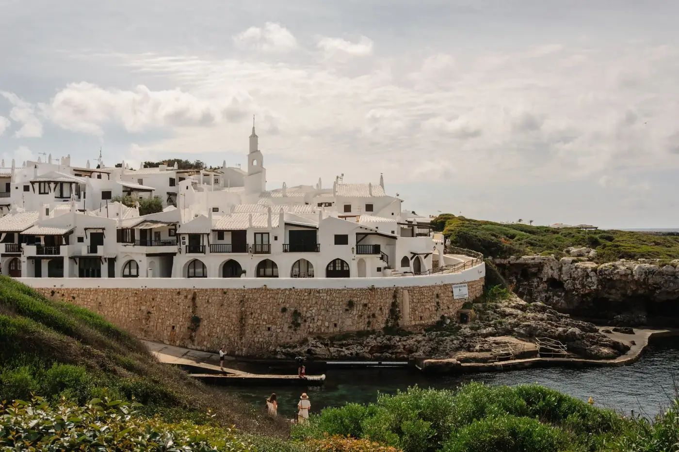 Charming white buildings along the coast in Ciutadella de Menorca, Spain.