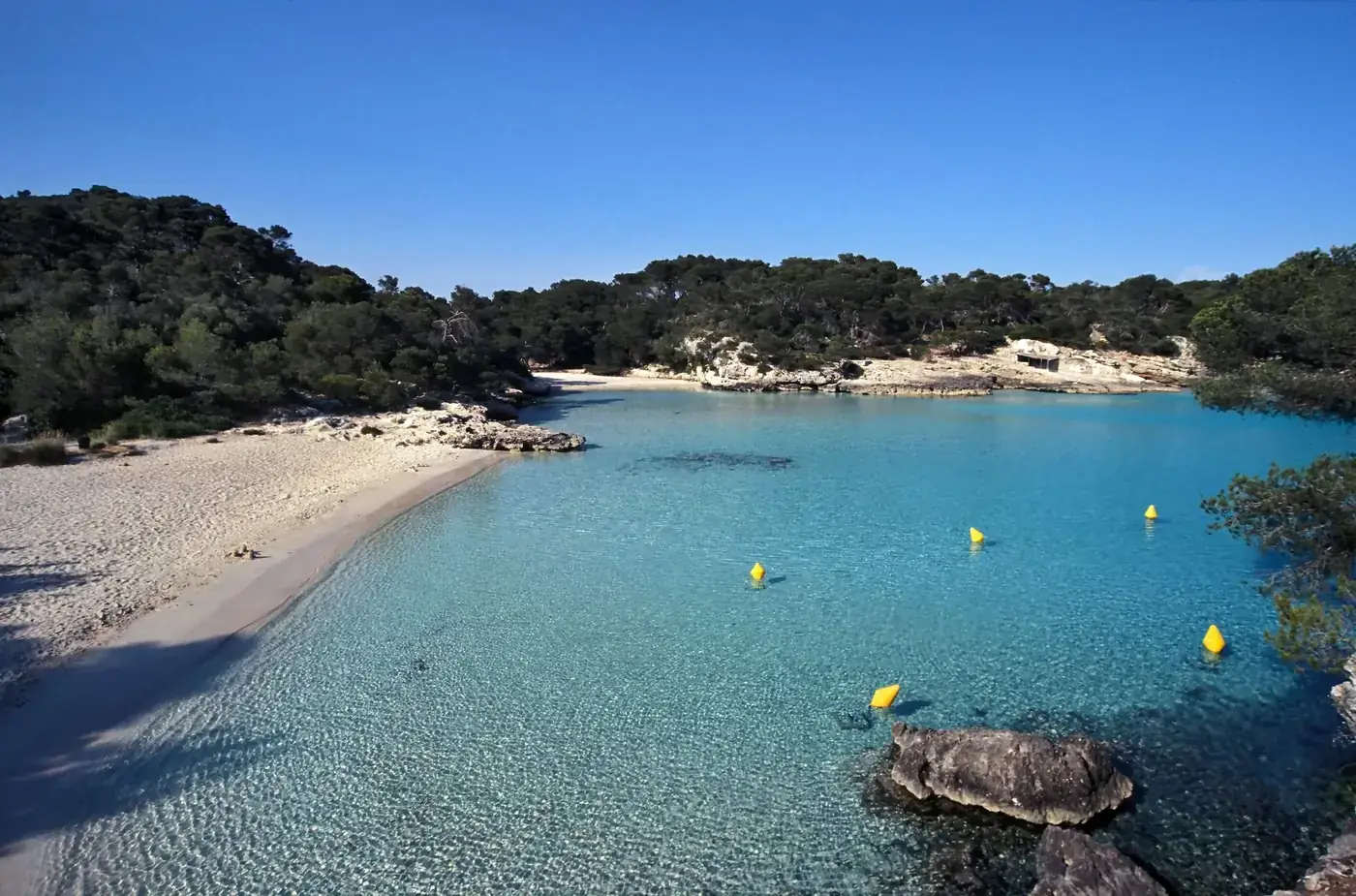 Serene beach cove with turquoise waters in Minorca, Balearic Islands.
