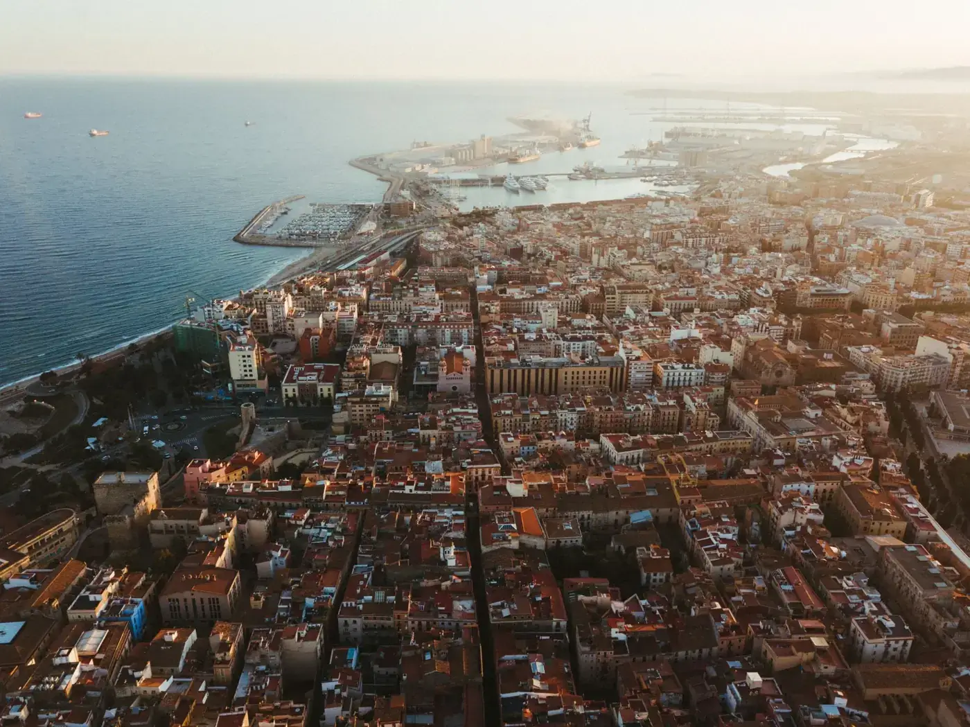 Stunning aerial view of Tarragona, Spain, highlighting its vibrant cityscape and coastline at sunset.