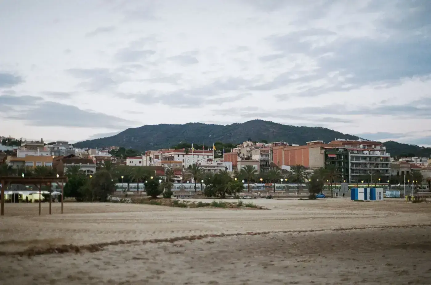 Scenic view of a coastal city in Barcelona, Spain, with sandy beach and hills.