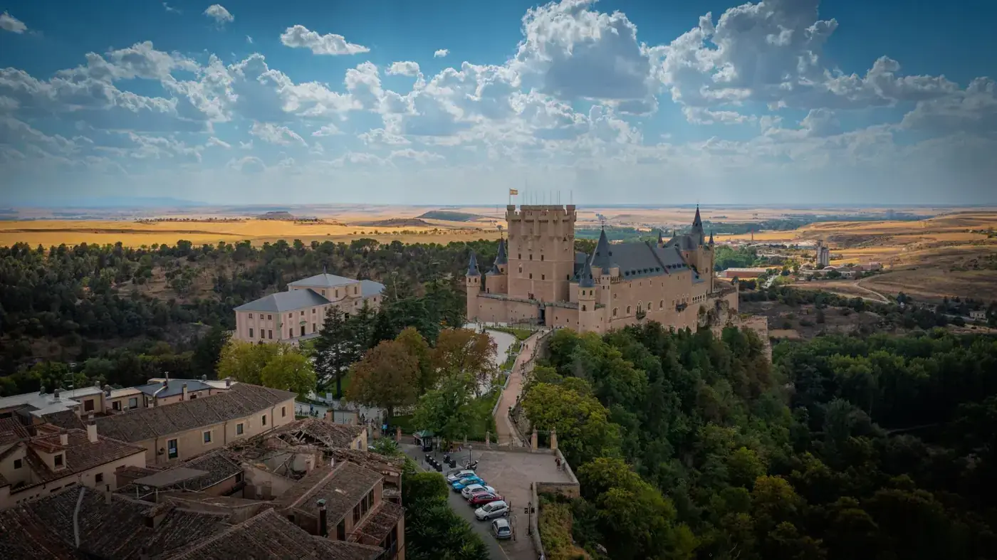 A stunning view of the Alcázar of Segovia set against a picturesque sky and landscape.