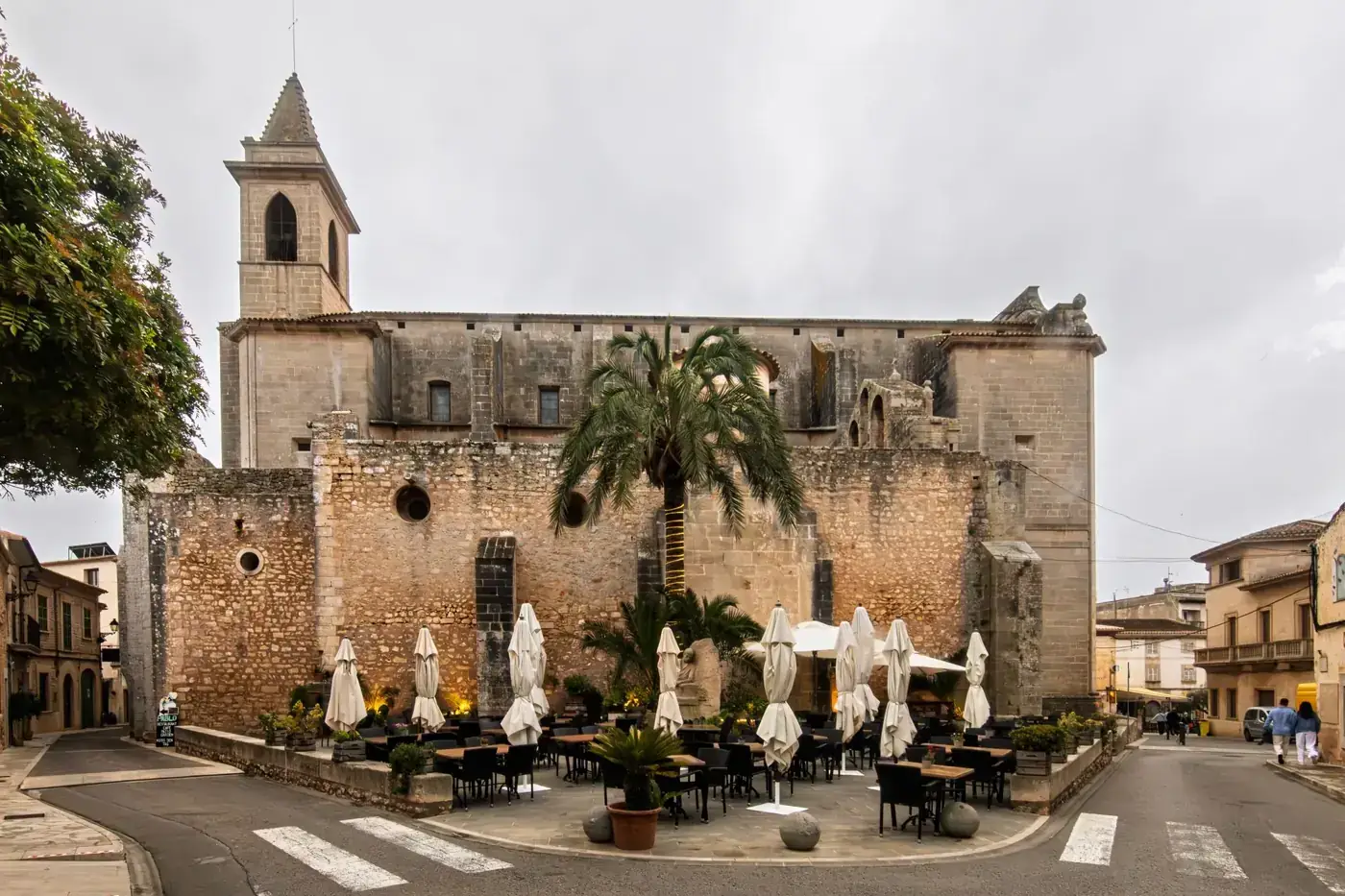 Charming outdoor cafe by a historical church in Santanyí, Mallorca.