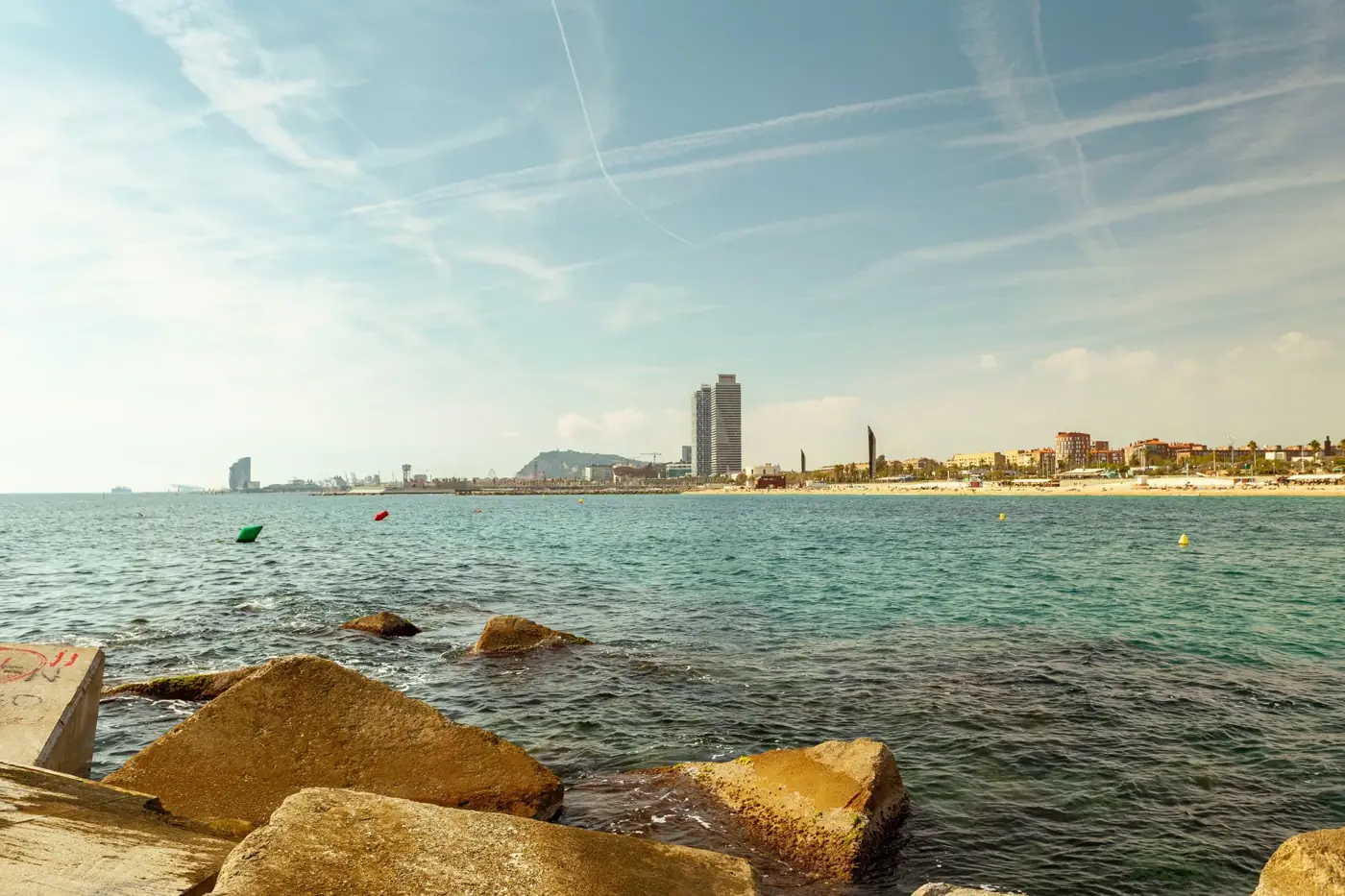 Scenic view of Barcelona's beachfront with the city skyline and clear blue waters.