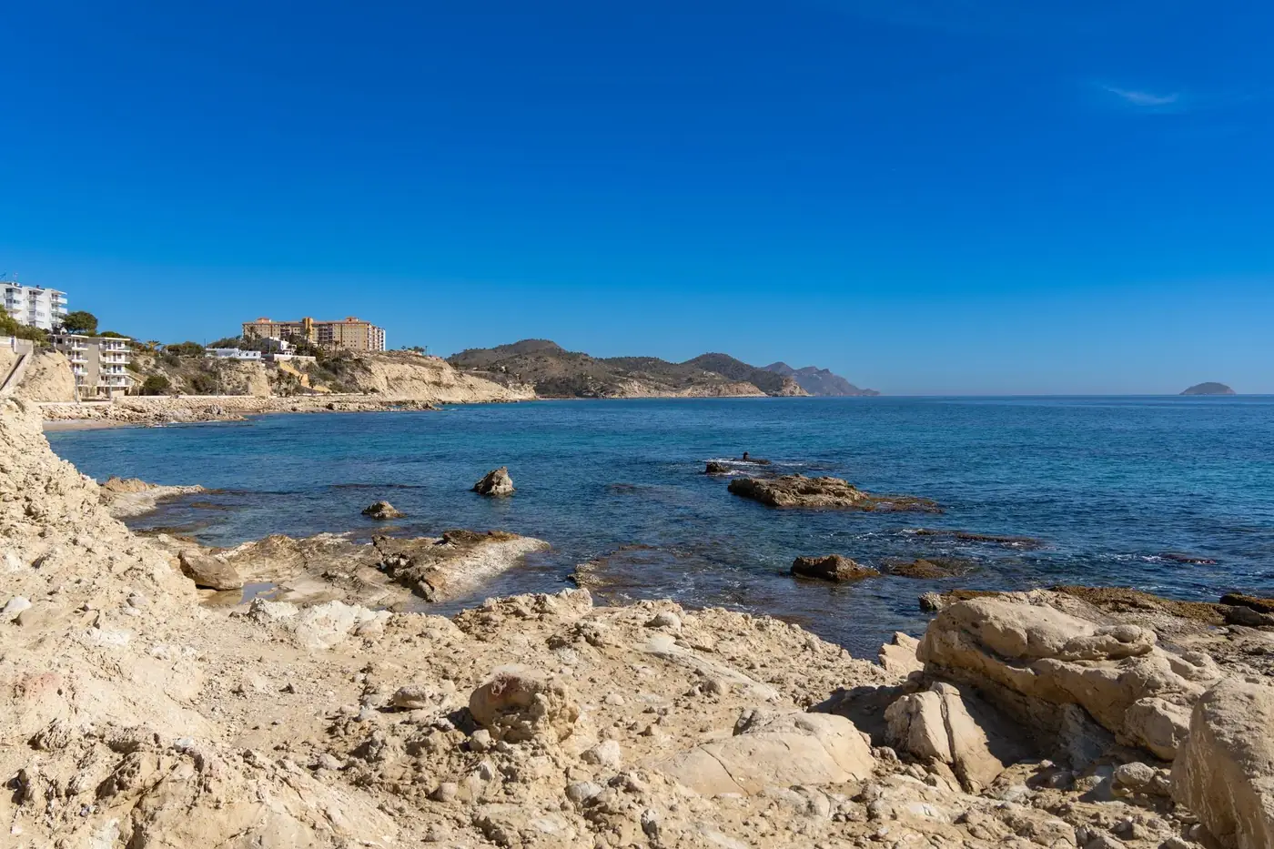 Rocky coastline of Villajoyosa, Spain with blue sea and clear sky