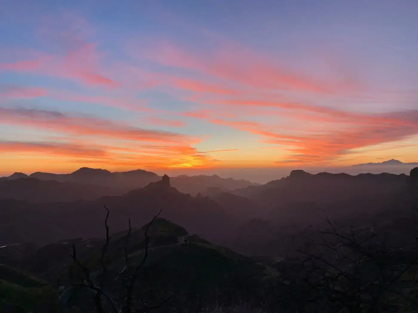 Dramatic sunset casting vivid colors over the mountainous landscape of Tejeda, Spain.