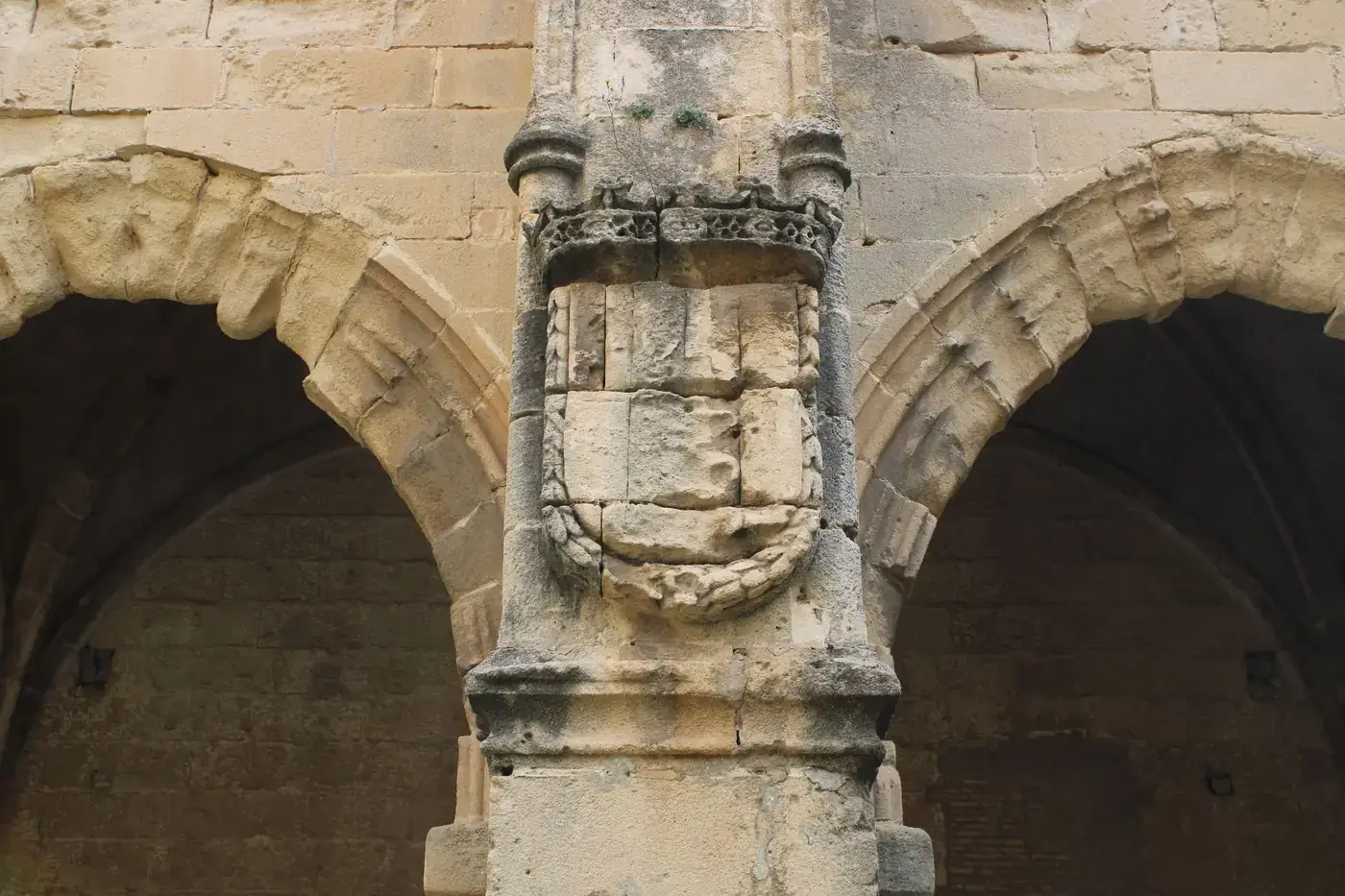 Close-up of a historic stone archway with intricate carvings in El Puerto de Santa María, Spain.