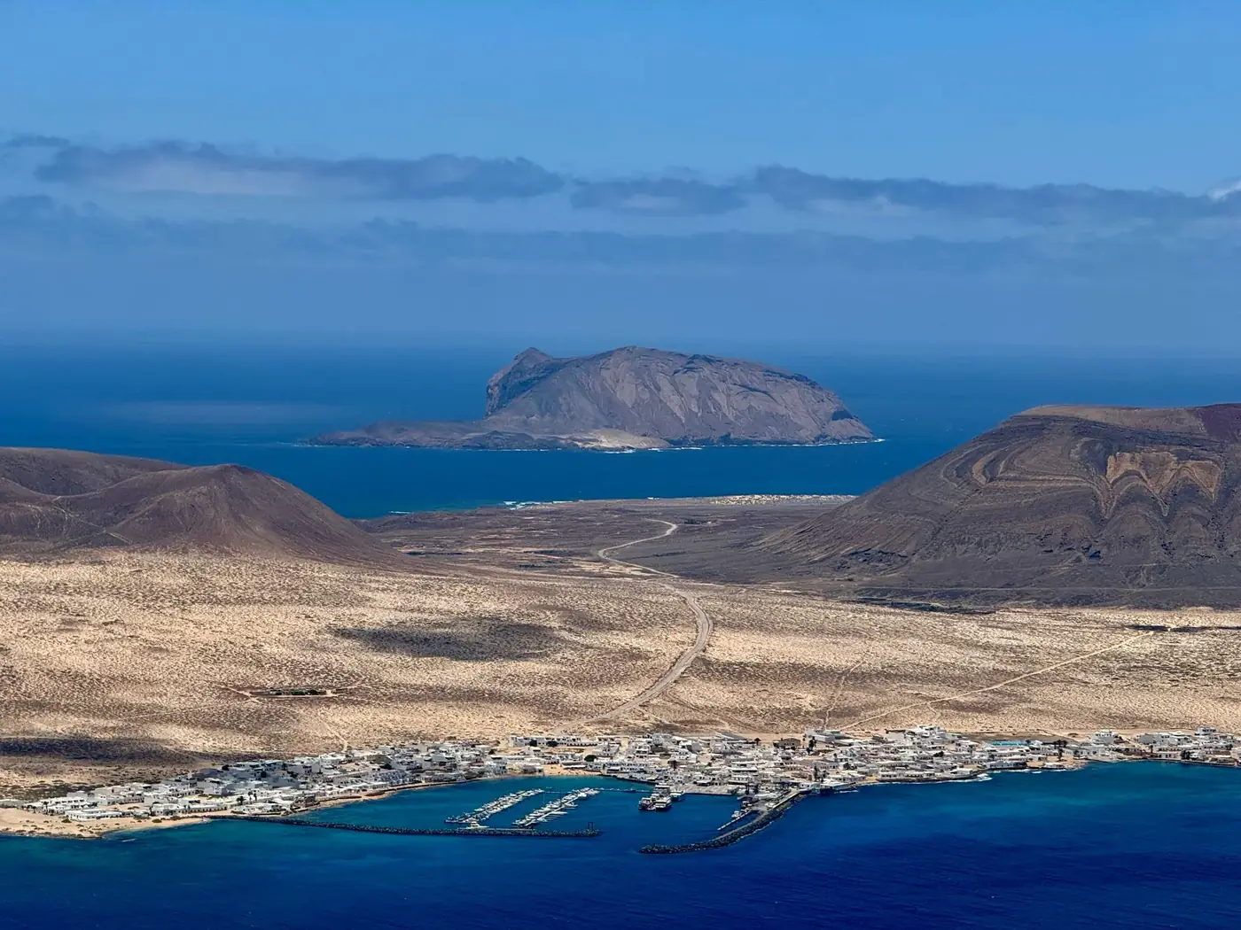 Explore Lanzarote's breathtaking landscapes with this stunning aerial view, featuring volcanic terrain and turquoise wat