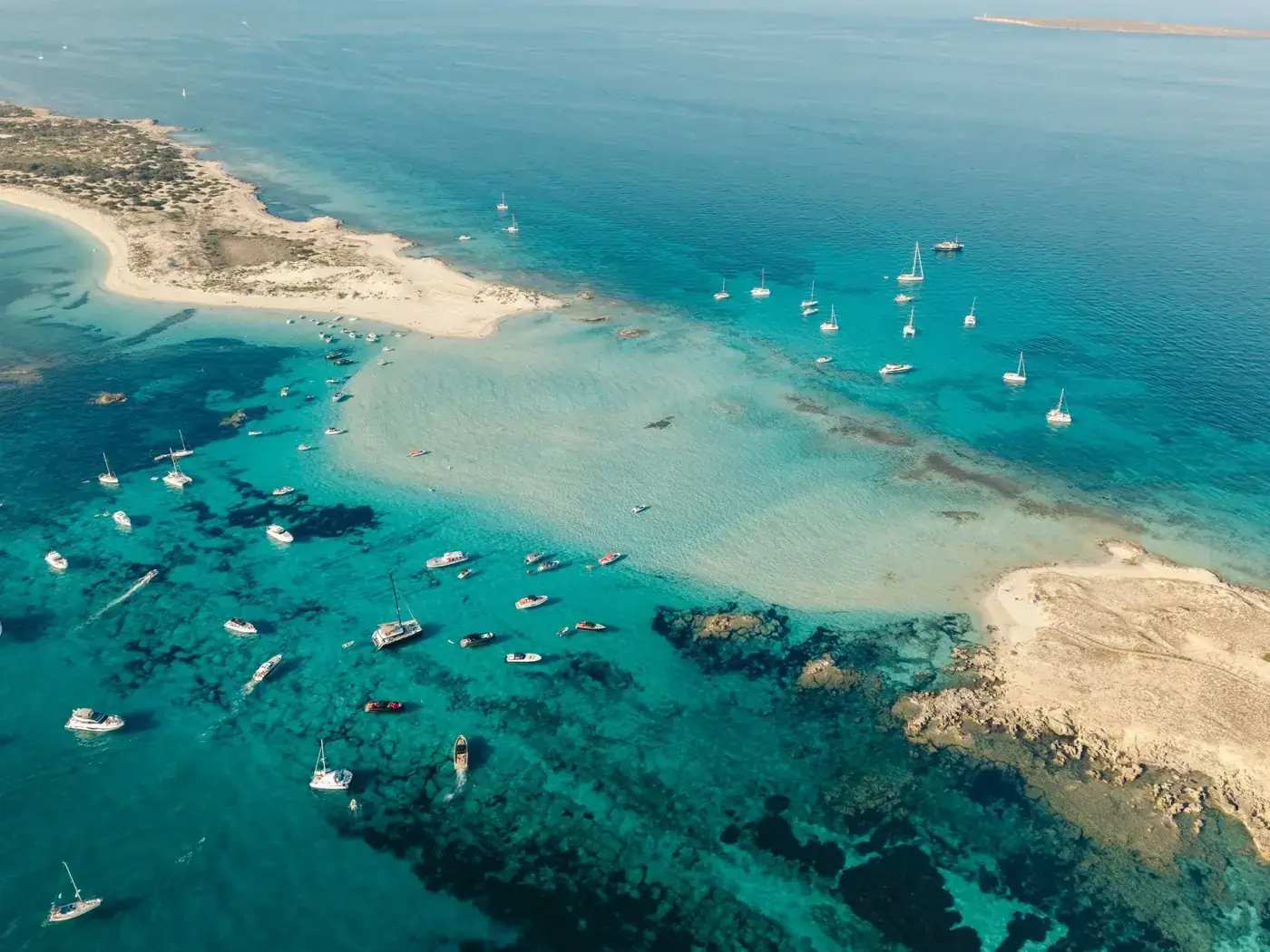 Stunning aerial view of sailboats and yachts in the turquoise waters of the Balearic Islands, Spain.