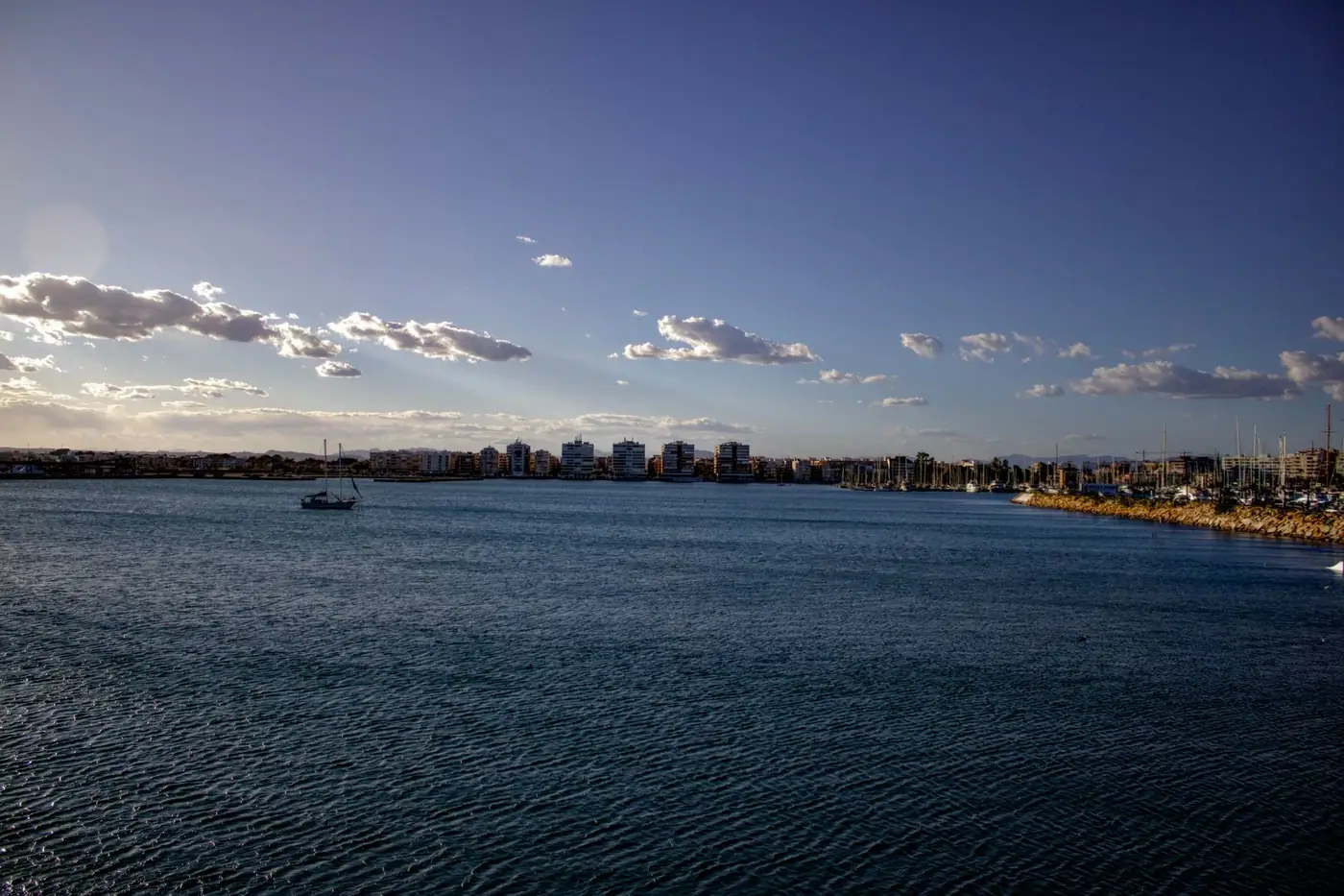 Beautiful coastal scene of Torrevieja, Spain during the day, featuring calm waters and a clear sky.