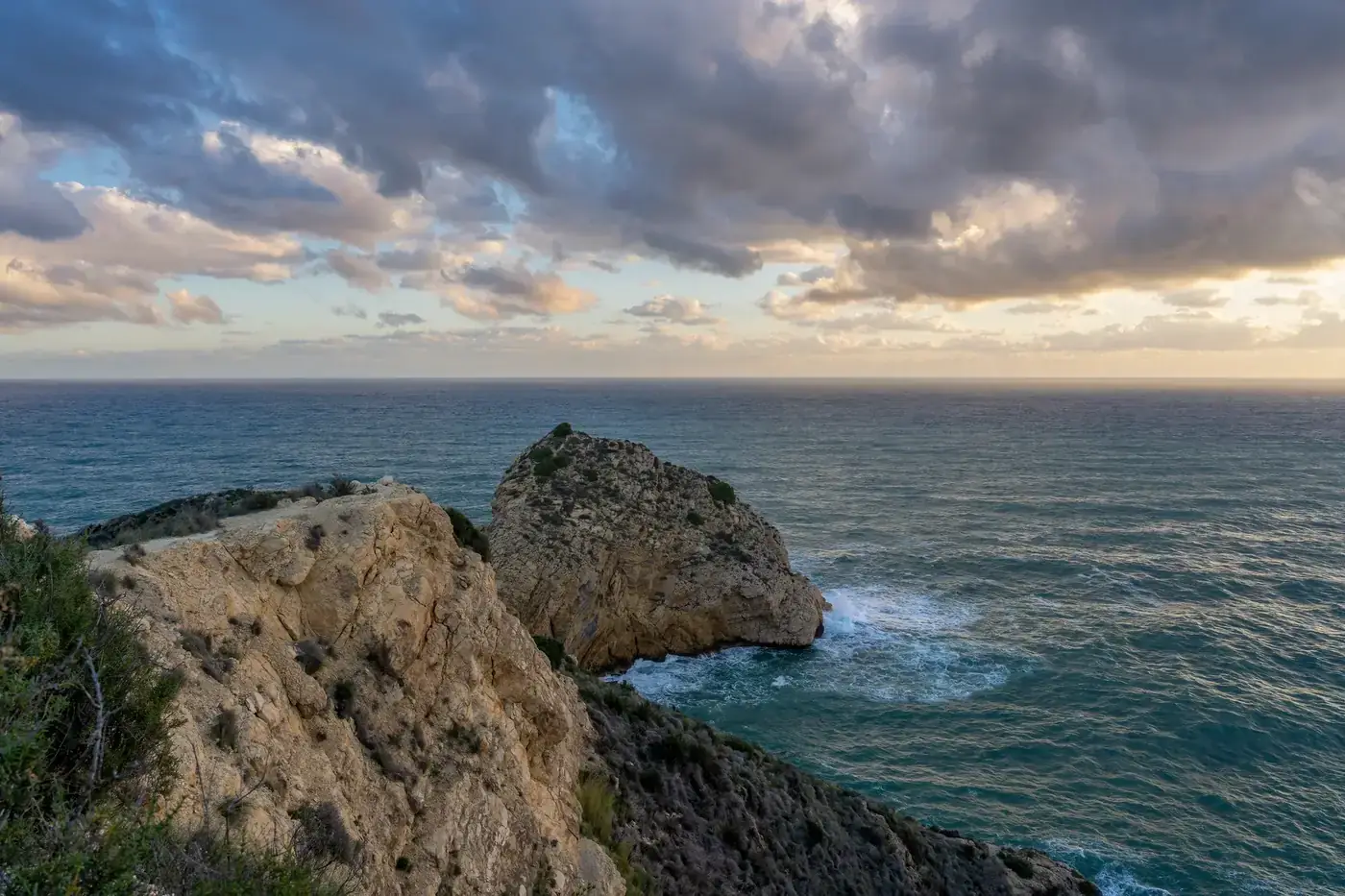 Breathtaking view of rugged cliffs and the Mediterranean Sea in Jávea, Spain at dawn.