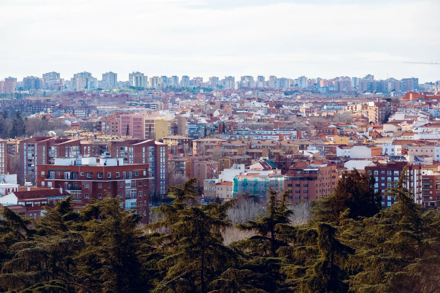 Aerial view of the vibrant cityscape of Madrid, showcasing diverse urban architecture under a clear sky.