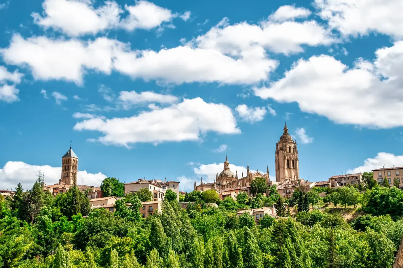 Picturesque cityscape of Segovia with cathedral towers under a vivid sky.
