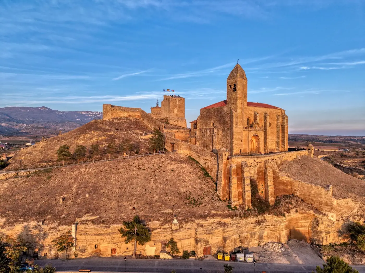 Dramatic aerial shot of a historic castle in La Rioja, Spain during golden hour.