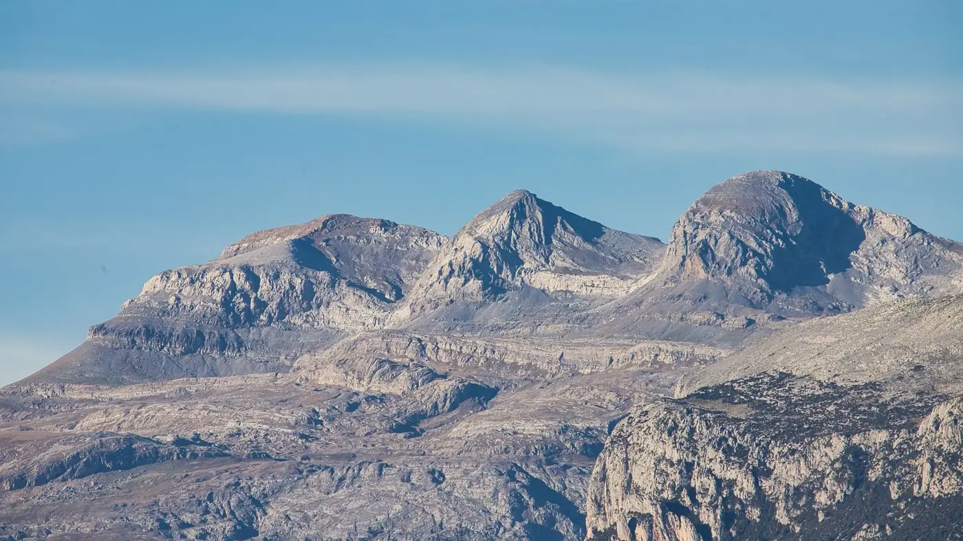 Scenic view of the Pyrenees mountains under a clear blue sky, showcasing stunning geological formations.