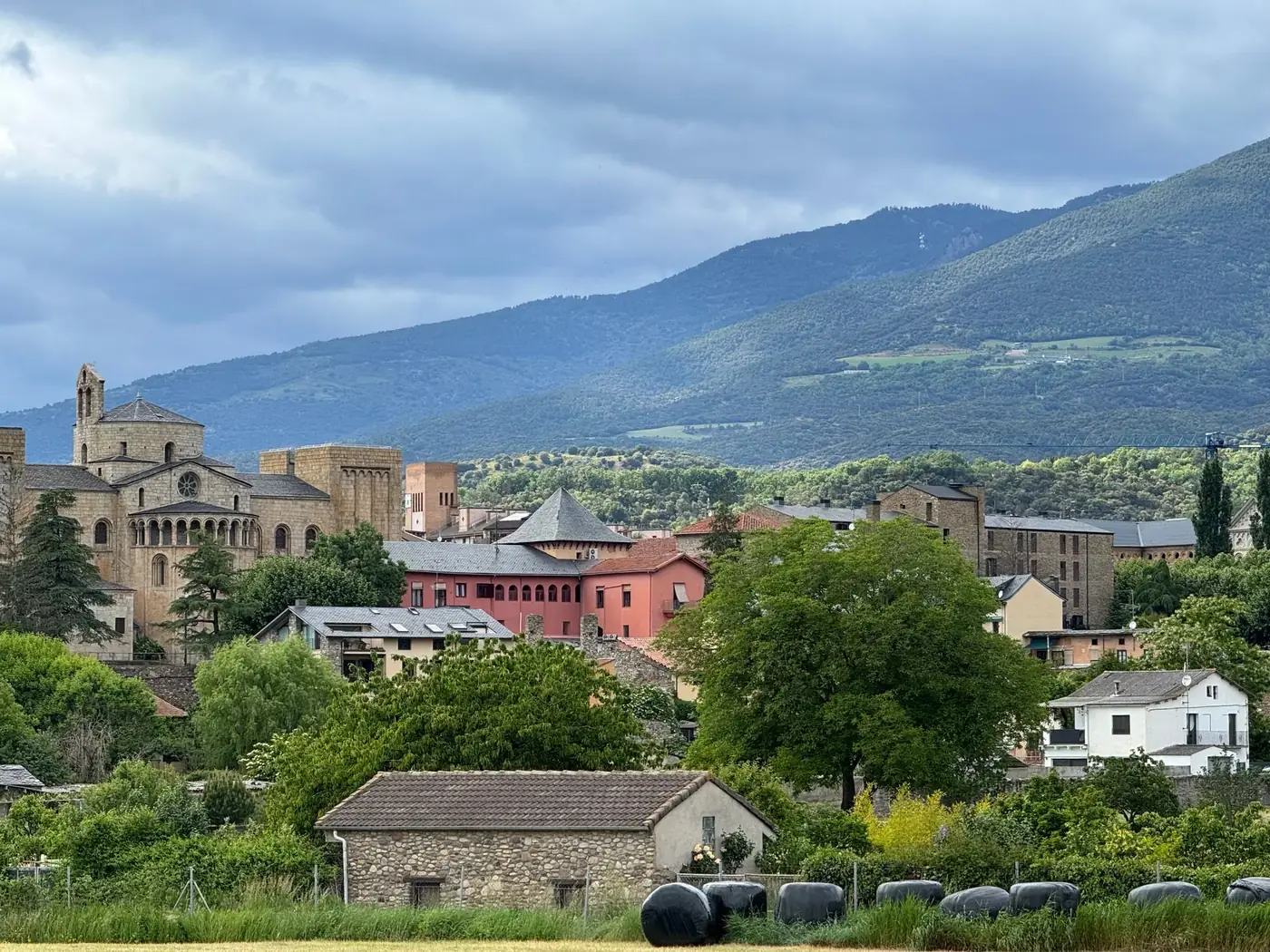 Scenic view of a picturesque mountain village with historic stone buildings and lush greenery.