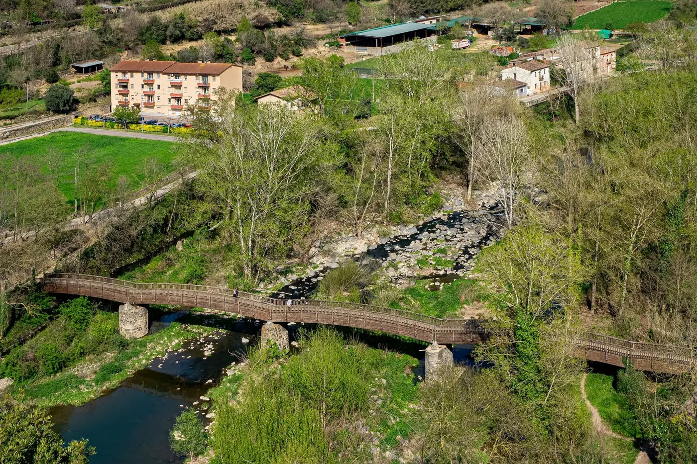 Aerial view of a footbridge over a river in Castellfollit de la Roca, Spain.
