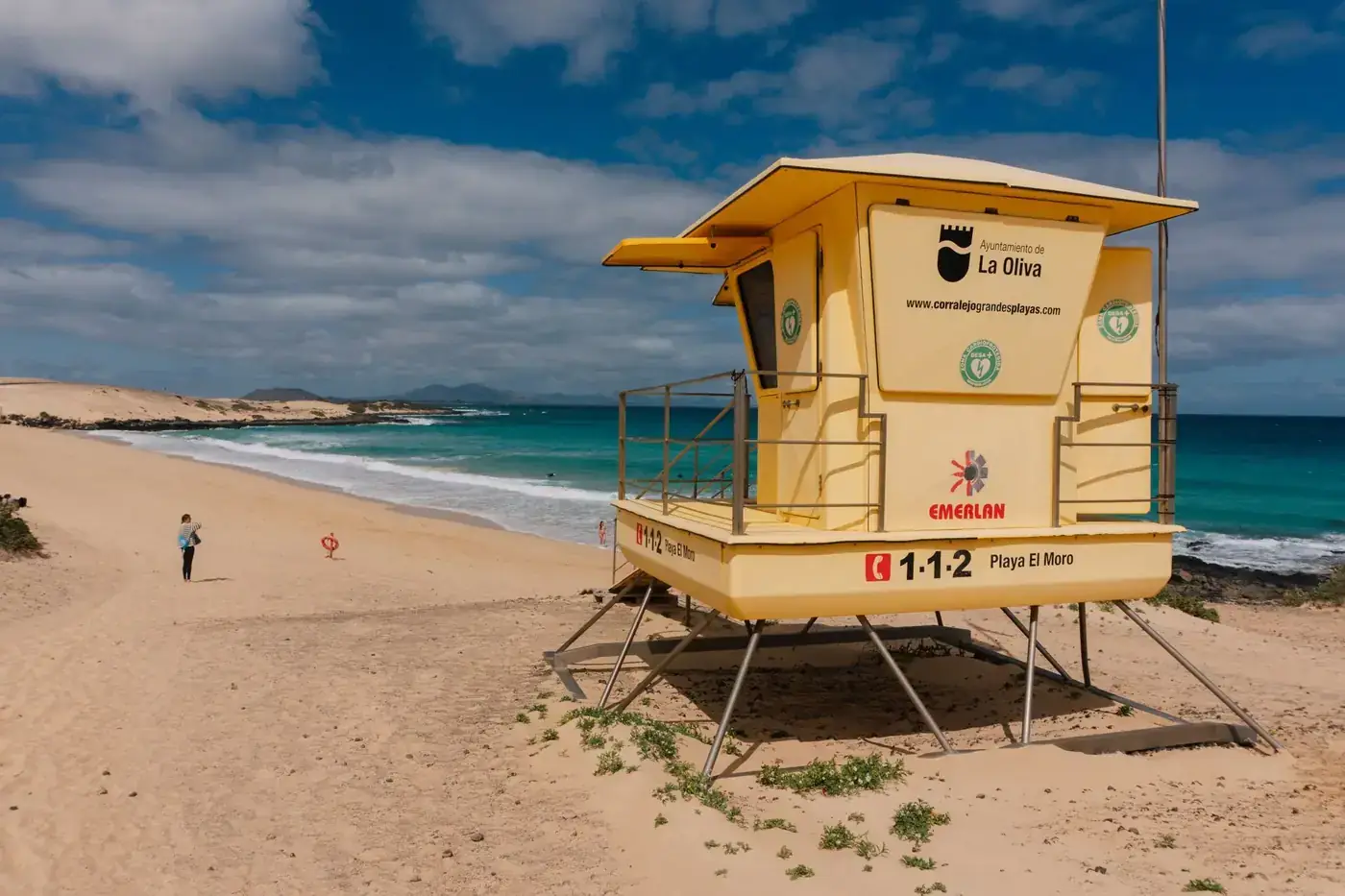 Coastal view of Playa El Moro, Fuerteventura, with a lifeguard tower and clear skies.