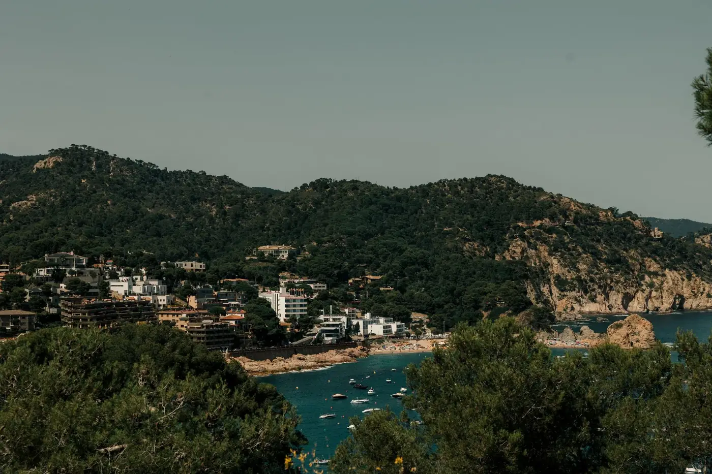 A breathtaking view of Tossa de Mar's coastline with lush greenery and clear waters.