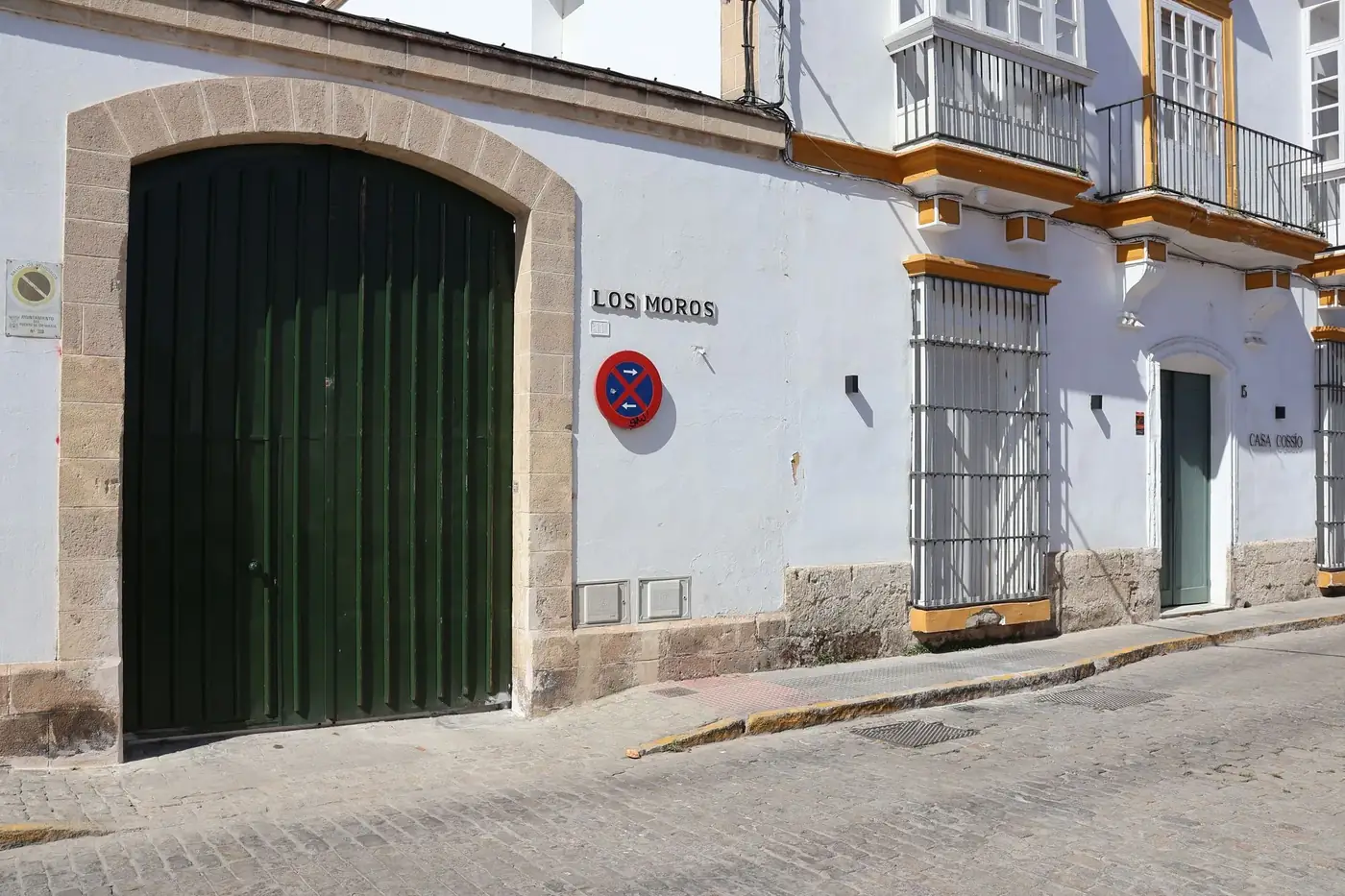 Whitewashed building façade with green door in Andalucía, Spain.