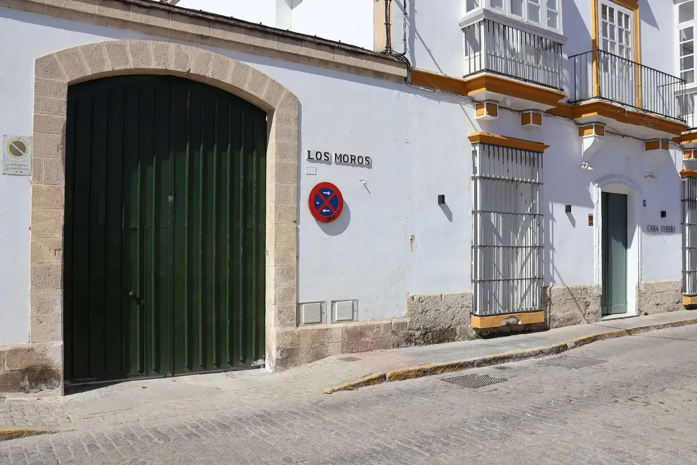 Whitewashed building façade with green door in Andalucía, Spain.