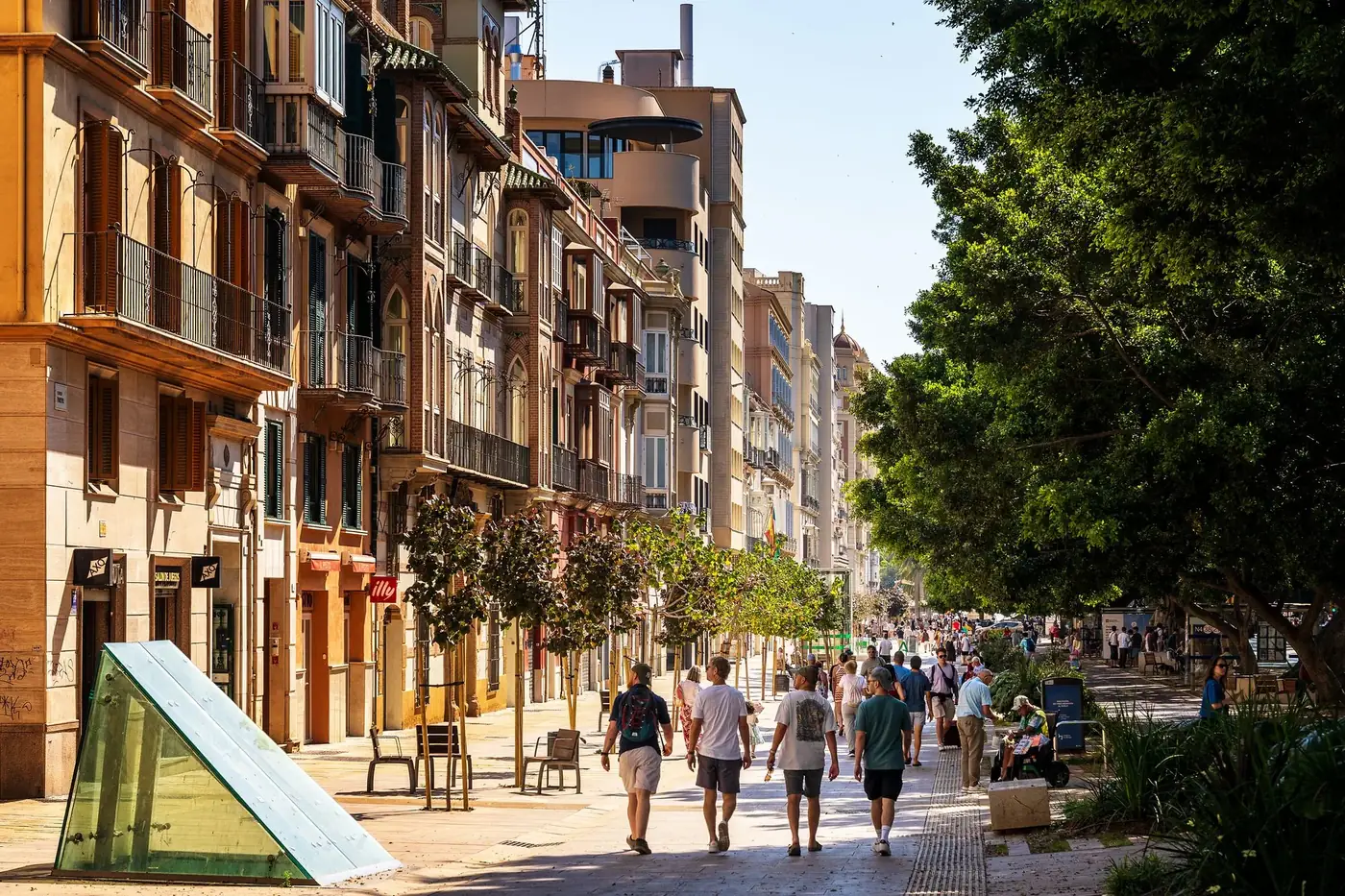 A bustling European street with pedestrians and classic architecture under the summer sun.
