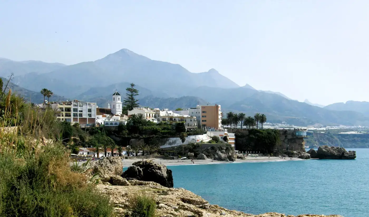 Picturesque coastal town of Nerja with stunning mountains and clear blue sea.