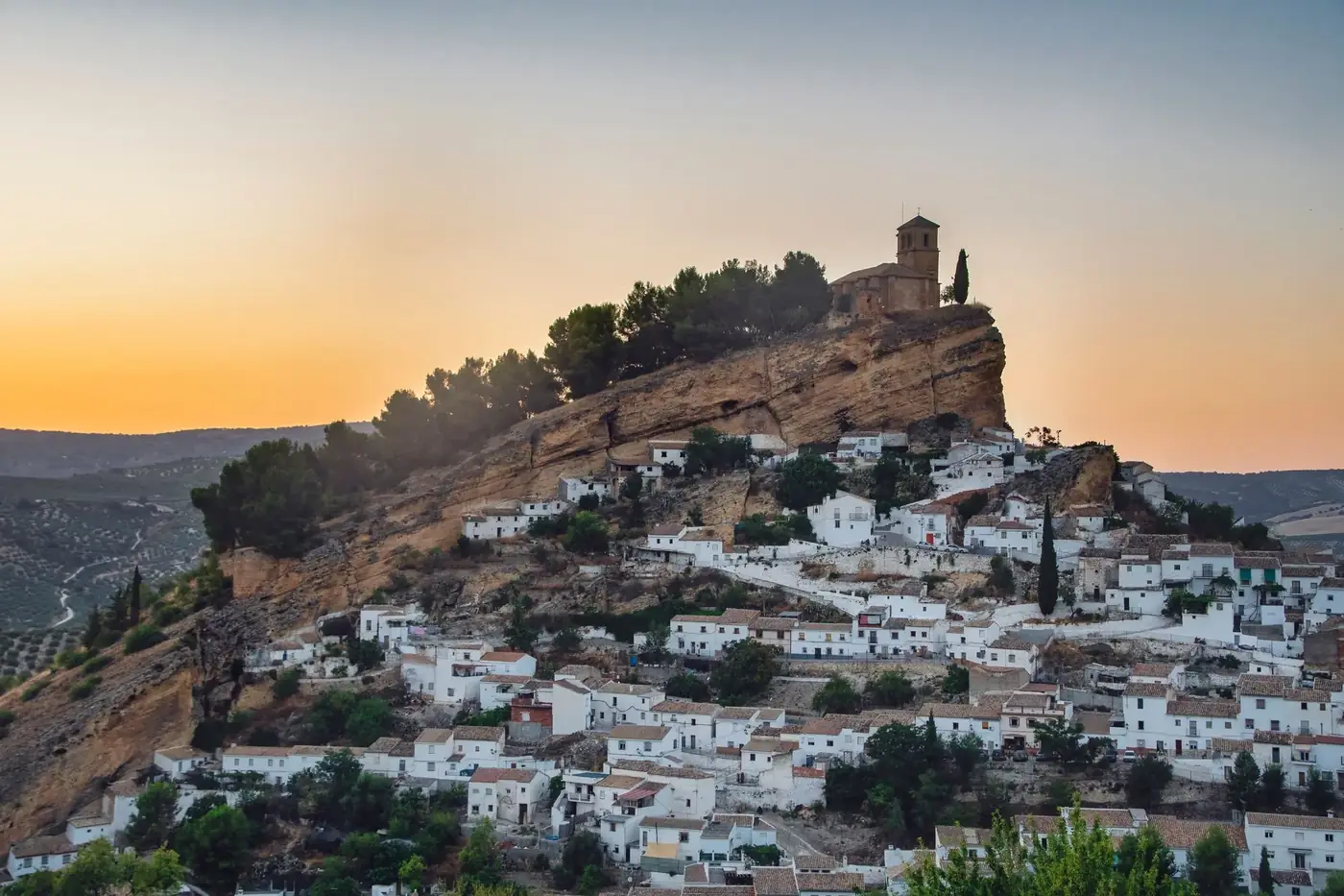 Picturesque view of Montefrio's iconic hilltop church and town at sunset.