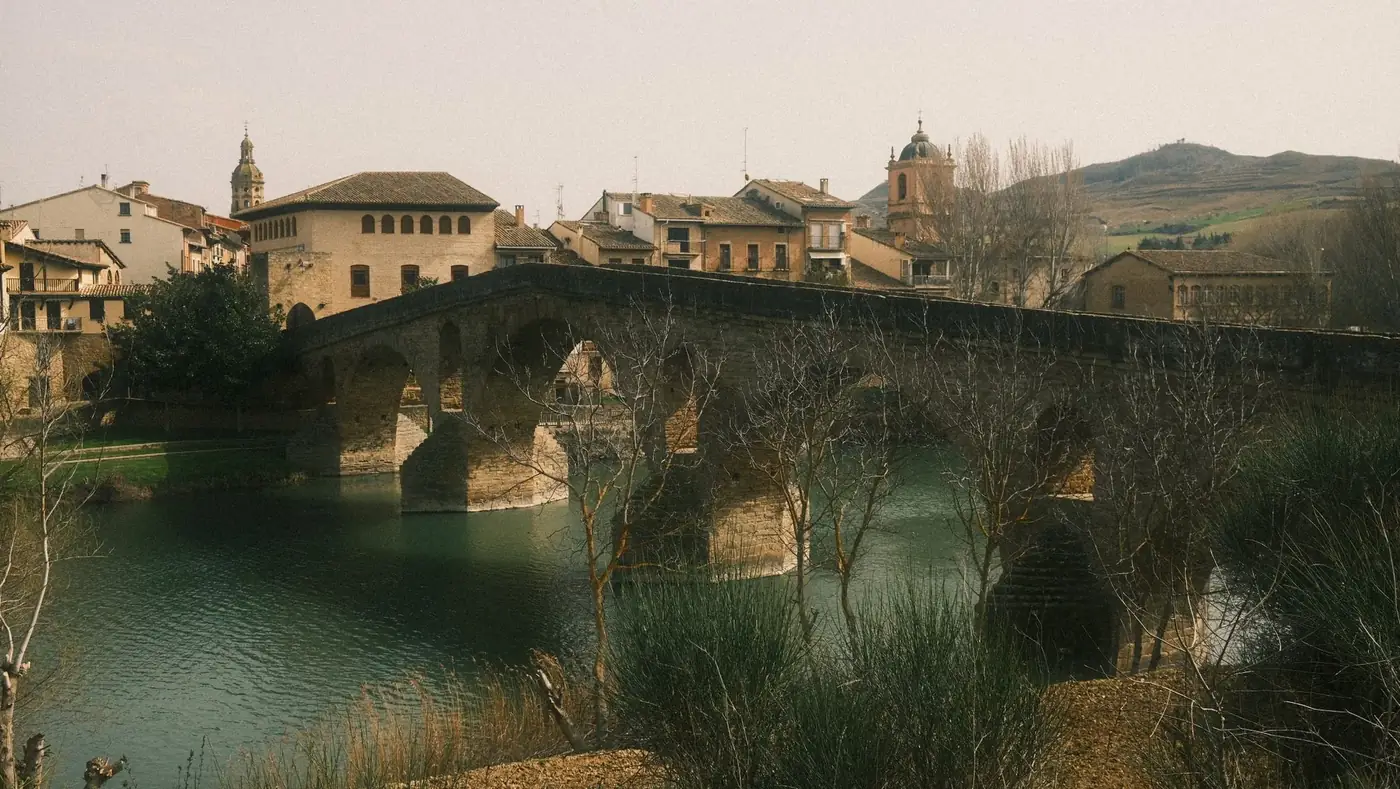 Scenic view of a historic stone bridge in Pamplona, Spain, with charming architecture.