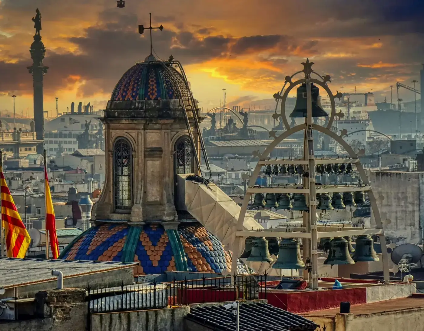 Captivating view of Barcelona's skyline featuring a colorful bell tower against a dramatic sunset.