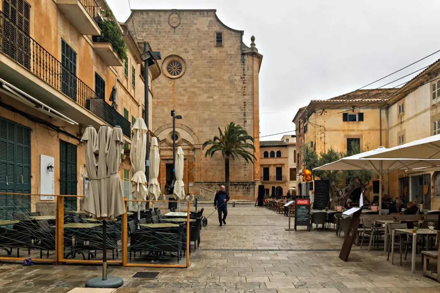 Explore a quaint European village square featuring cafes, historic architecture, and a serene ambiance.