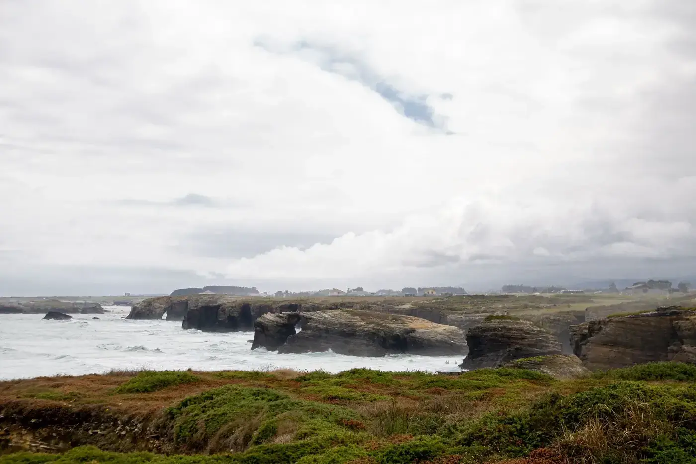 Explore the stunning coastal cliffs of Lugo, Spain with lush greenery and crashing waves.