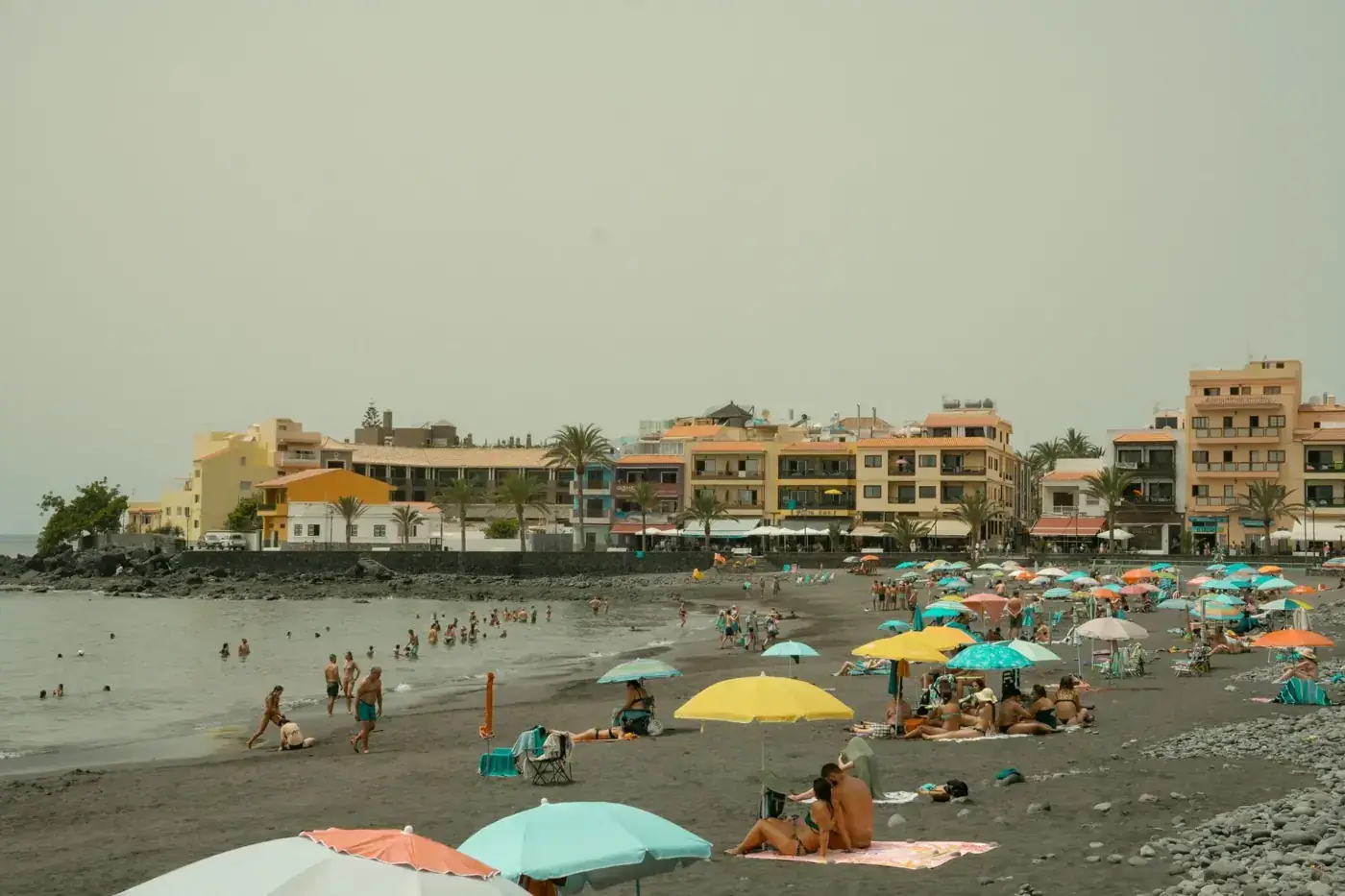 Relaxing summer day on a vibrant black sand beach in Valle Gran Rey, Canary Islands.